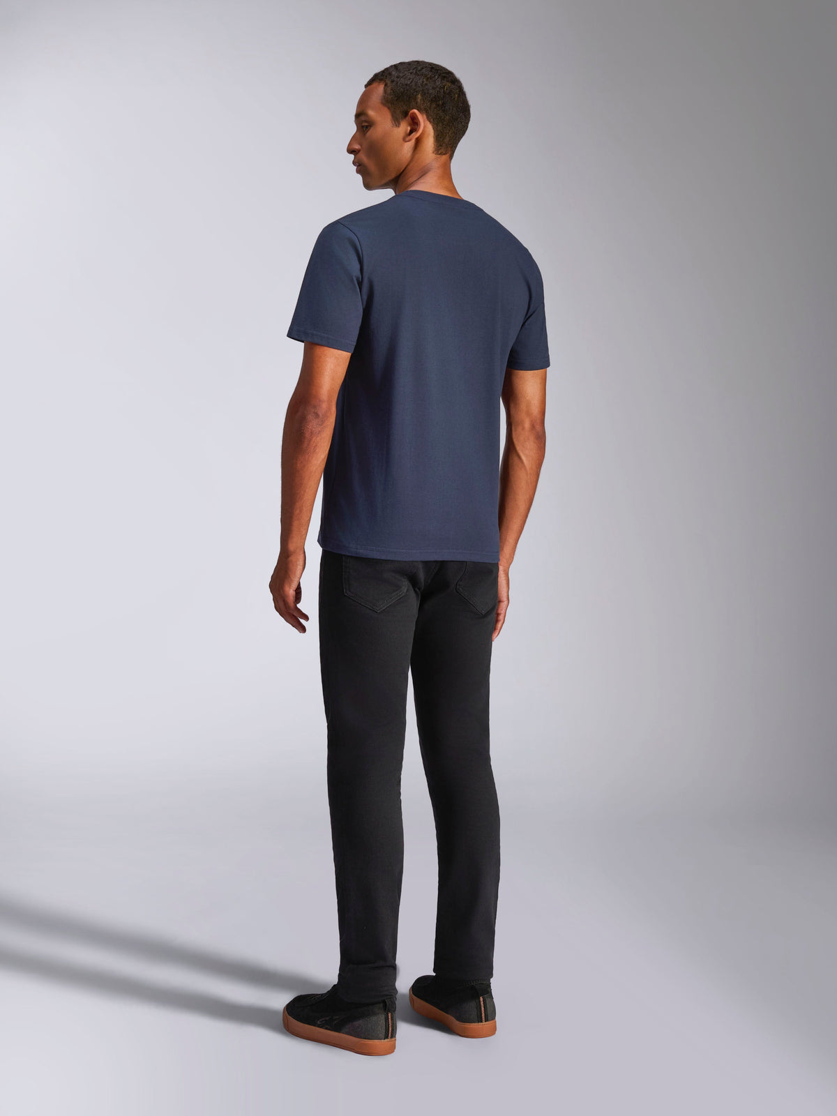 Alpinestars Ride 4.0 CSF Tee, Marineblau, kurzärmeliges T-Shirt, Rückansicht, getragen von einem Modell mit schwarzer Hose, lässige vom Motorsport inspirierte Lifestyle-Kleidung