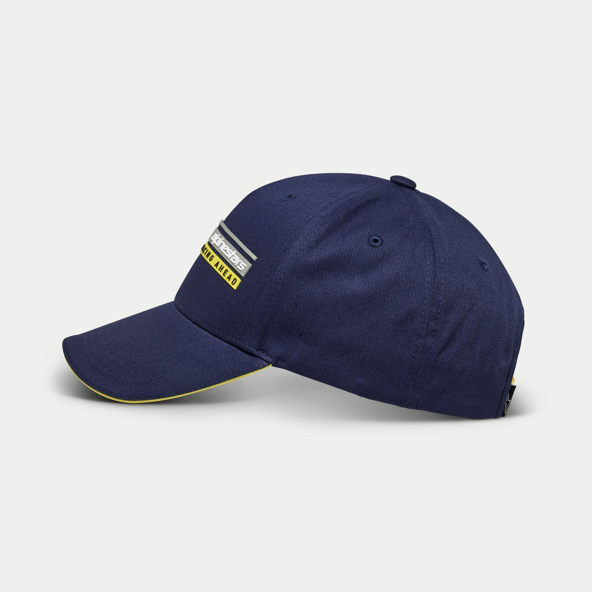 Alpinestars Par Mütze, marineblaue Baseball-Cap, Seitenansicht, strukturierte Krone mit gebogenem Schirm und gelbem Sandwich-Detail, Alpinestars Racing Ahead lineares Logo 3D-Stickerei, lässige, vom Motorsport inspirierte Kopfbedeckung