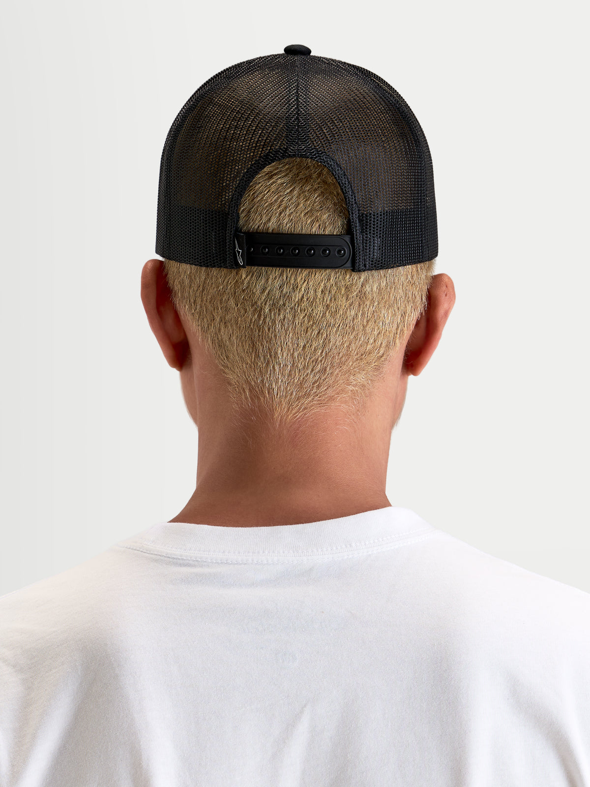 Alpinestars Heritage Patch Trucker-Kappe, schwarze Freizeitmütze mit Mesh-Rückseite, Rückansicht mit verstellbarem Snapback-Verschluss und Poly-Mesh-Konstruktion an einem Model