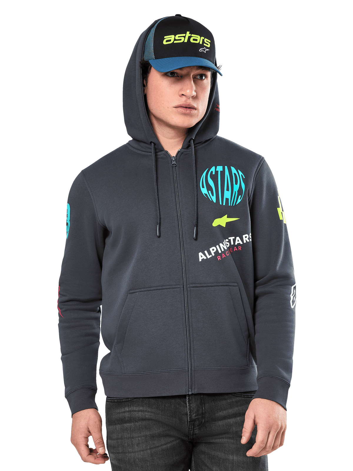 Alpinestars Variegate Hoodie, Fleece-Hoodie mit Reißverschluss vorne, Gunmetal-Grau mit mehrfarbigen Logo-Grafiken auf der Brust und den Ärmeln, getragen von einem Model mit passender Kappe, lässige Streetwear mit Kängurutaschen und durchgehendem Reißverschluss