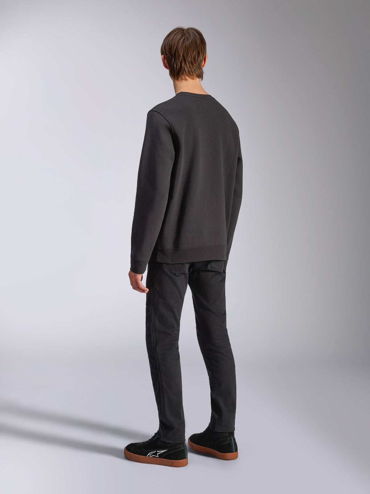 Alpinestars Positive Crew, Black Pullover Sweatshirt, back view on model, casual motorsport-inspired streetwear, featuring a ribbed hem and cuffs.