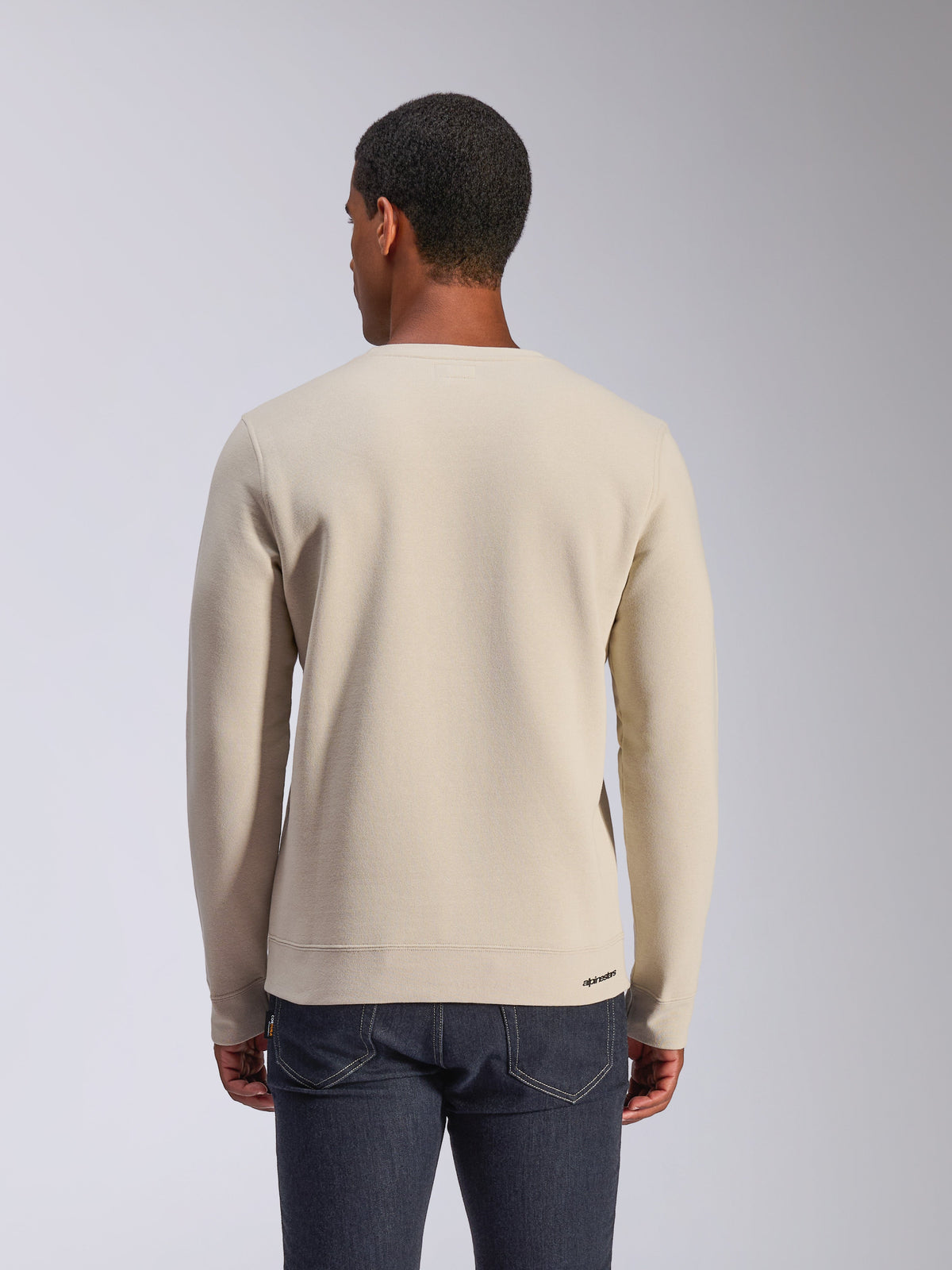 Alpinestars Positive Crew, Off-White Sweatshirt mit Rundhalsausschnitt, Rückansicht, lässige Motorsport-Streetwear, gerippter Saum und Ärmelbündchen, mit kleinem Alpinestars-Logo am hinteren Saum