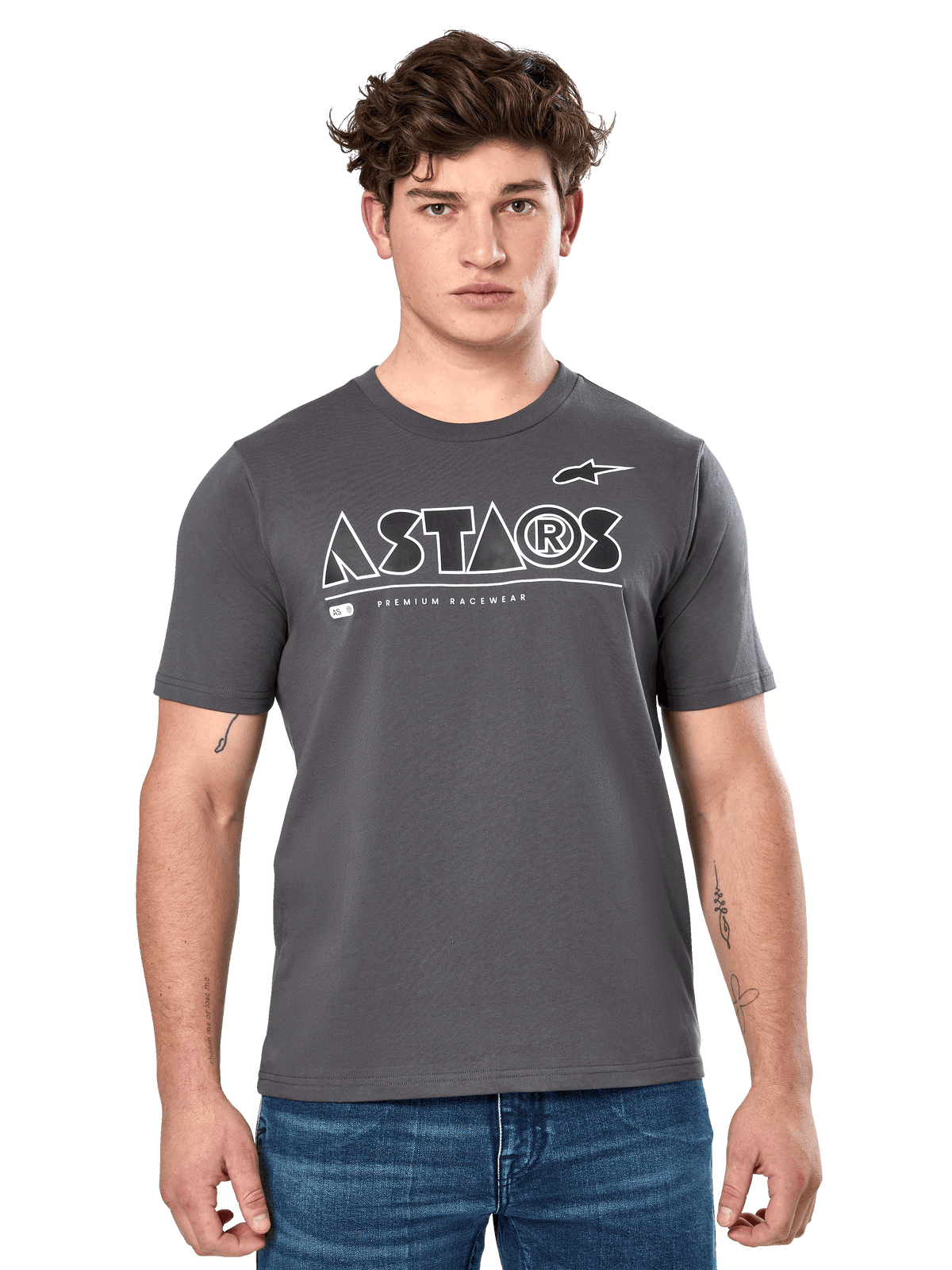 Alpinestars Cereal CSF Tee, anthrazitgraues Kurzarm-T-Shirt, getragen von einem männlichen Model mit blauen Jeans, weißes geometrisches ASTARS-Logo und „Premium Racewear“-Schriftzug, lässige motorsport-inspirierte Lifestyle-Bekleidung