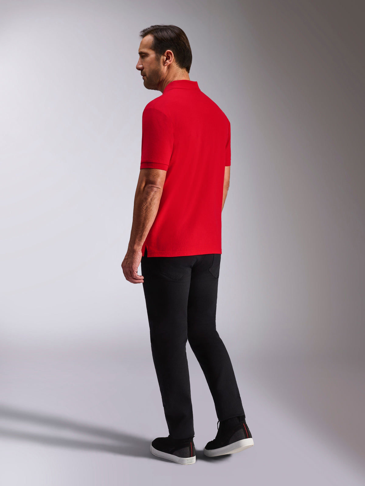 Alpinestars Endeavor Classic Polo, Short Sleeve Pique Polo Shirt, Red, back and side view, featuring a ribbed collar and cuffs, worn with black pants and shoes, casual motorsport-inspired streetwear