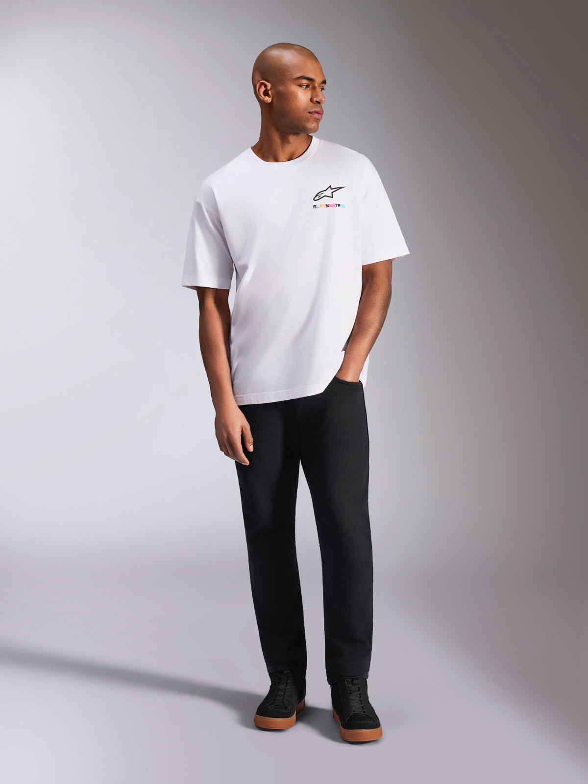 Alpinestars Wild Oversized CSF Tee, Short Sleeve T-Shirt, White, vibrant multi-color Astars logo on chest, worn with black pants and sneakers, casual motorsport lifestyle apparel