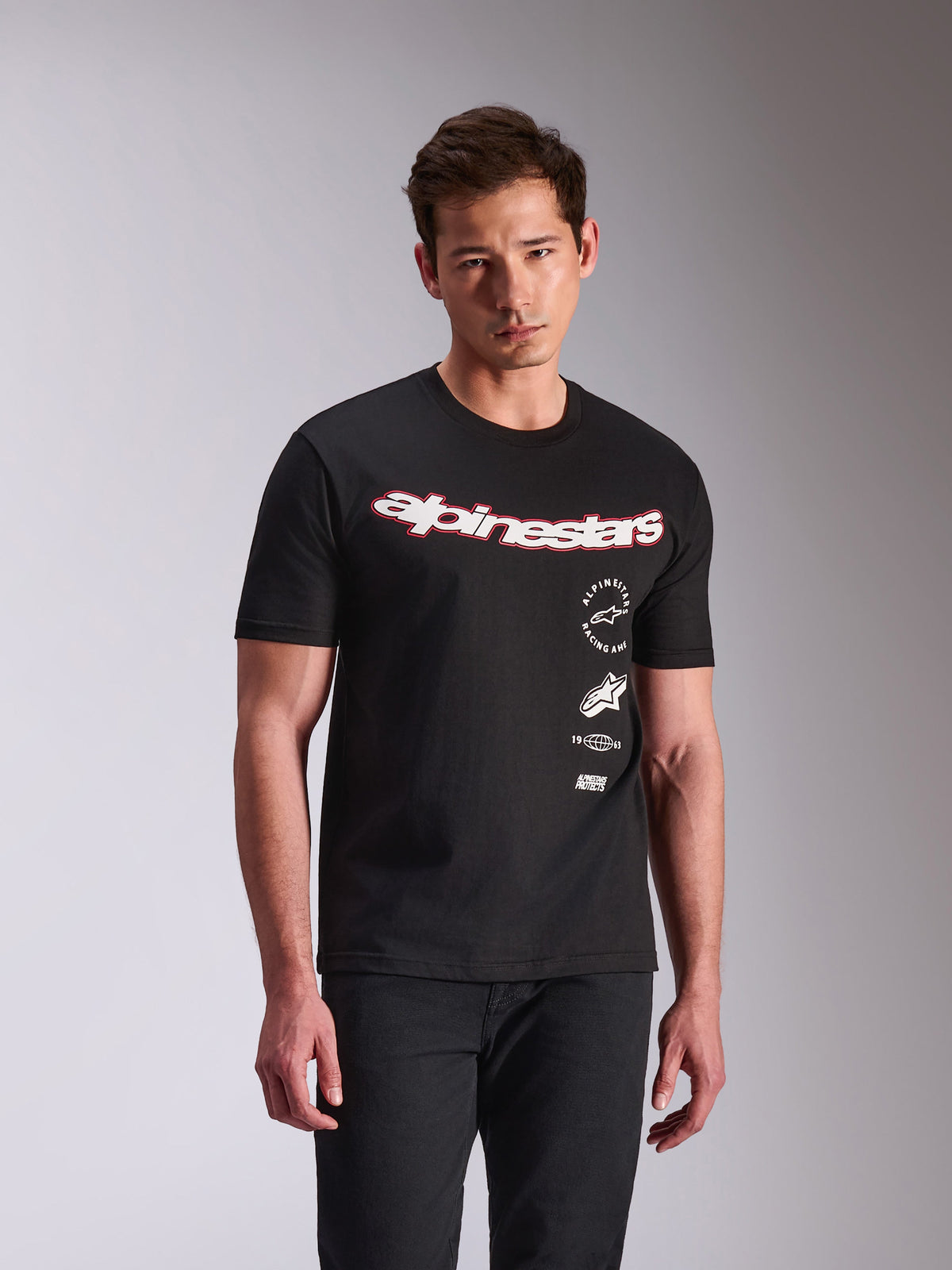 Alpinestars Abus CSF Tee, kurzärmeliges T-Shirt, Schwarz, weißes geschwungenes Alpinestars-Logo mit roter Umrandung, gestapelte Seitengrafiken, lässige Motorsport-Streetwear