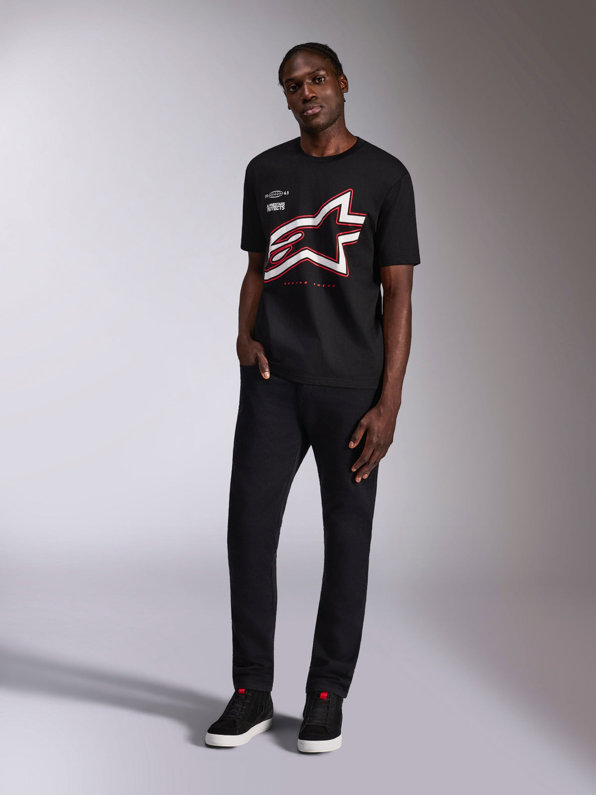 Alpinestars Authority CSF Tee, kurzärmeliges T-Shirt, Schwarz, großes beschnittenes Astars-Logo mit roten und weißen Umrissen, von einem Model getragen, lässige Motorsport-Streetwear