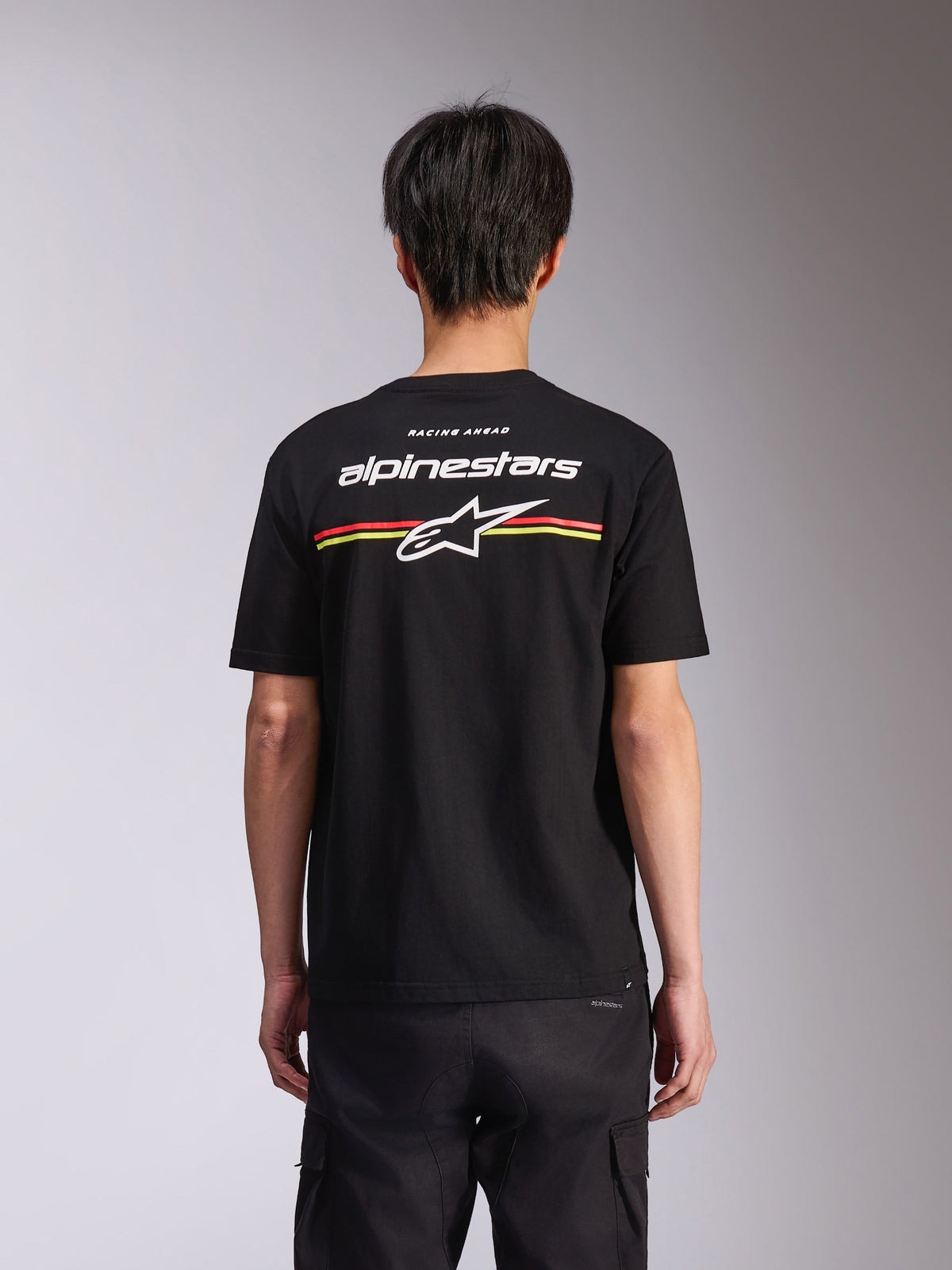 Alpinestars Lanes CSF Tee, Kurzarm-T-Shirt, Schwarz, Rückansicht mit weißem Alpinestars-Logo und Astars-Stern mit roten und gelben Streifen, Casual Motorsport Streetwear