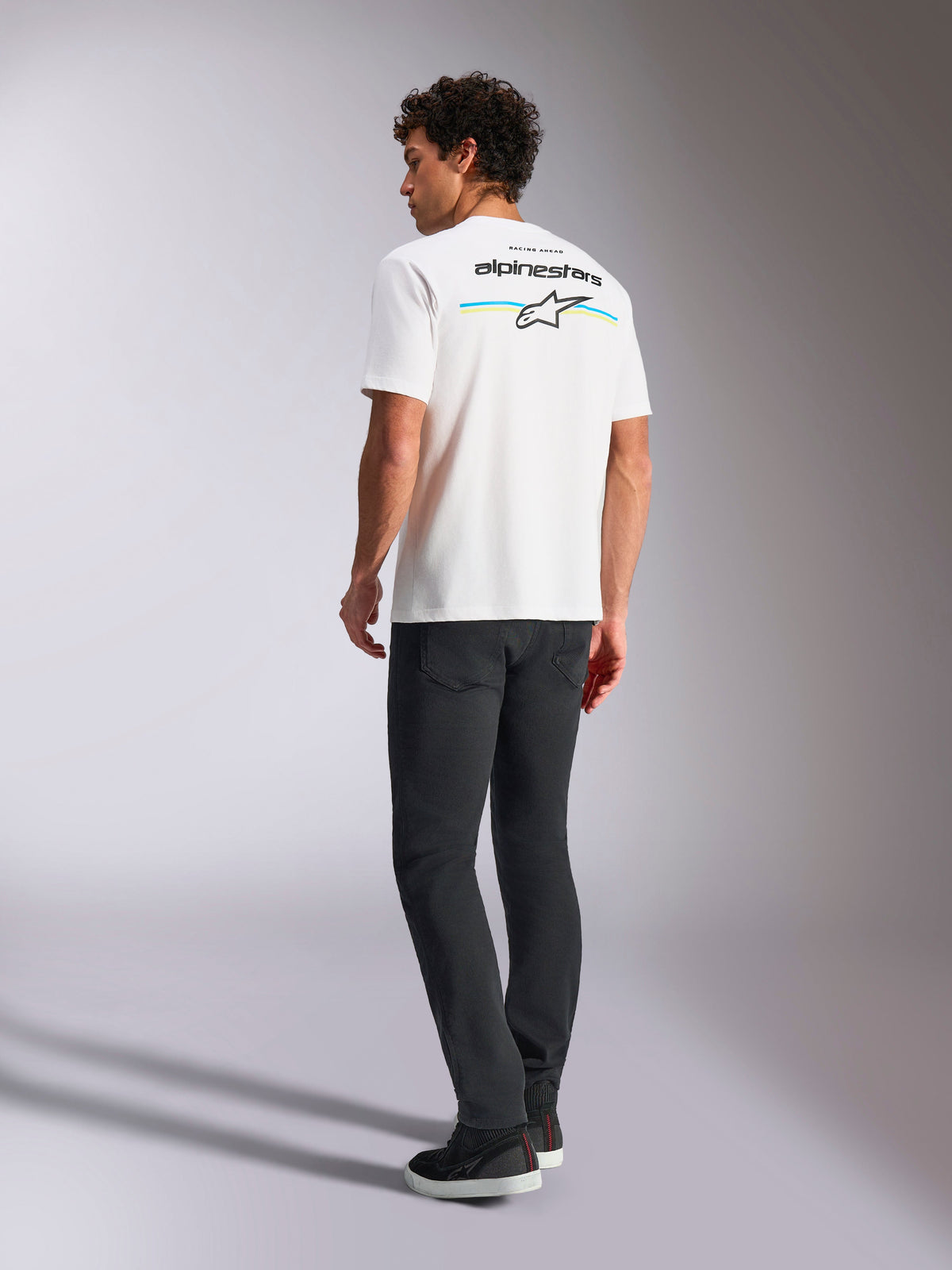 Alpinestars Lanes CSF Tee, kurzärmeliges T-Shirt, Weiß, Rückansicht mit Alpinestars-Logo sowie gelben und blauen Streifen, lässige Motorsport-Streetwear