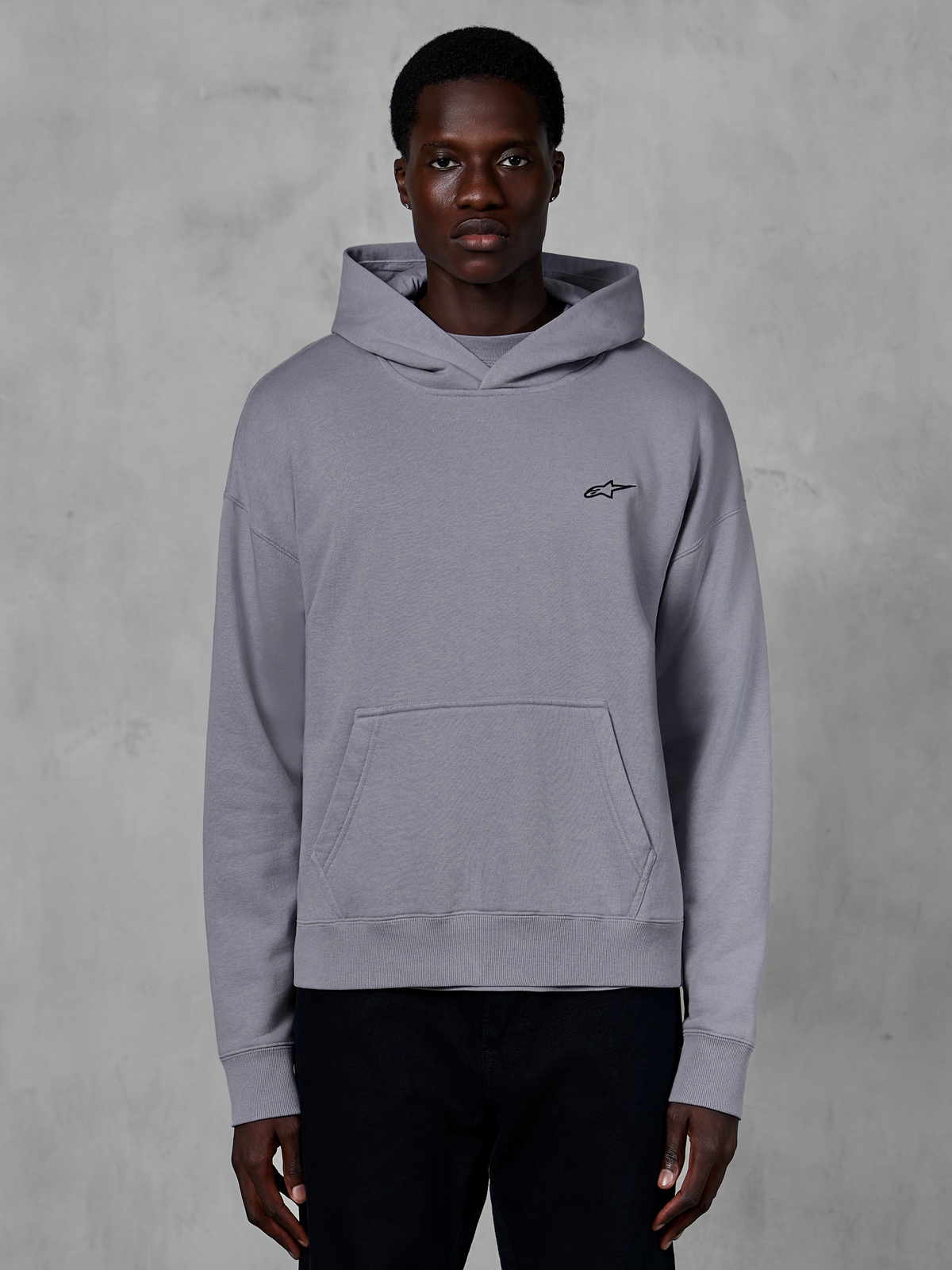 Alpinestars Essentials Ageless Hoodie, silberner Kapuzenpullover, lässige Streetwear, mit einem kleinen schwarzen Astars-Logo auf der Brust, Kängurutasche vorne, Kapuze mit Crossover-Ausschnitt und weichem Stone-Wash-Finish.