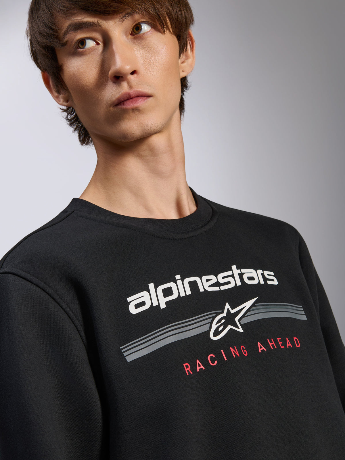 Alpinestars Bettern Crew Pullover, schwarzes Sweatshirt, weißes Alpinestars-Logo mit roter „Racing Ahead“ Textgrafik, Rundhalsausschnitt, lässige, vom Motorsport inspirierte Streetwear