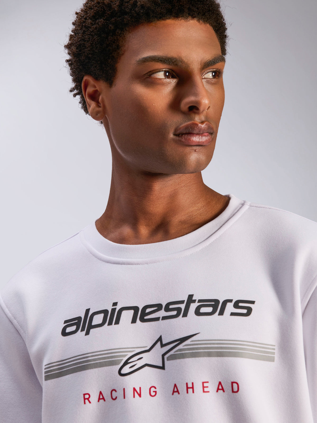 Alpinestars Bettern Crew, weißer Fleece-Rundhalspullover, schwarzes Alpinestars-Logo mit grauen horizontalen Linien und rotem „Racing Ahead“-Schriftzug, lässige, vom Motorsport inspirierte Streetwear