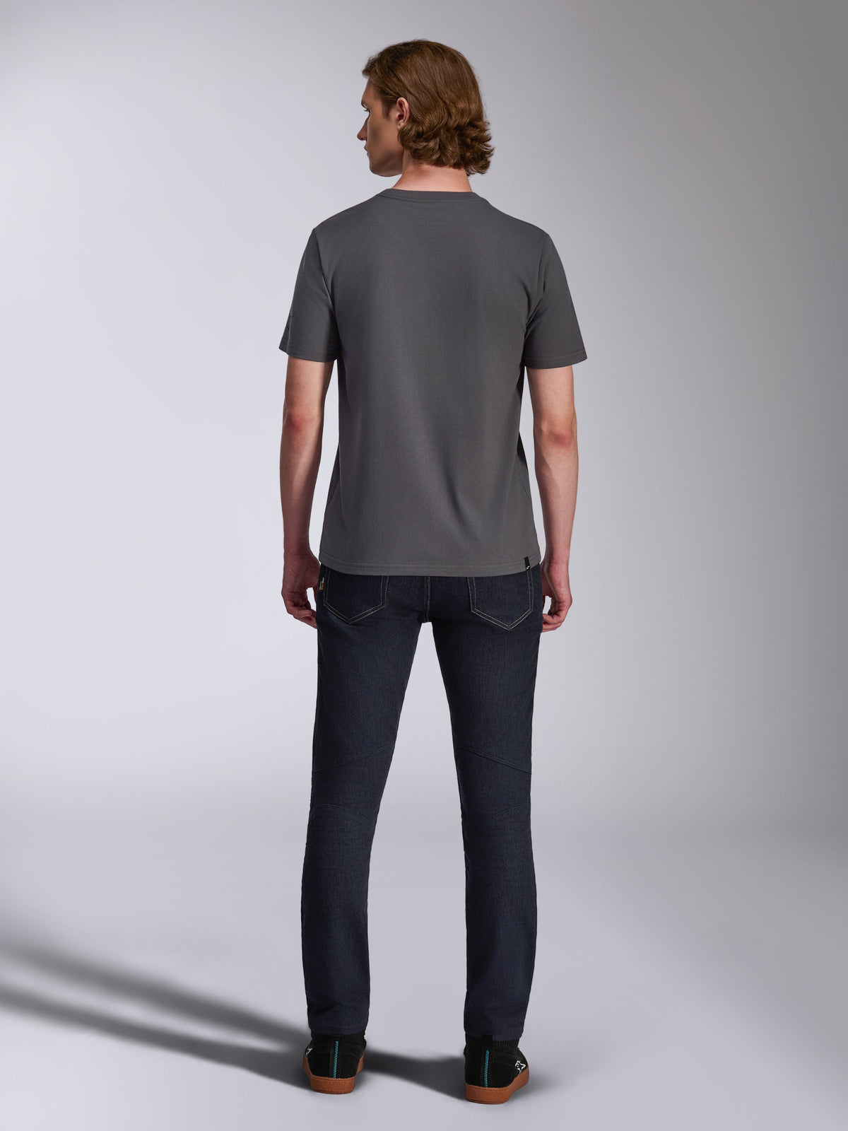 Alpinestars Waving CSF Tee, Kurzarm-T-Shirt, Anthrazit, Rückansicht, getragen mit dunklen Denim-Jeans, lässige, vom Motorsport inspirierte Streetwear