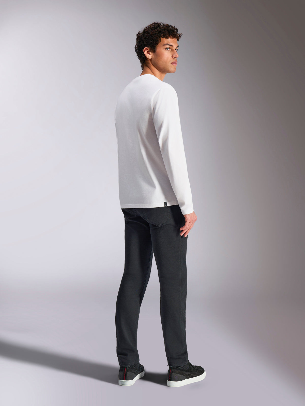 Alpinestars Trackside CSF Tee, Langarm-T-Shirt, Weiß, männliches Model in der Rückansicht, trägt eine schwarze Hose, lässige vom Motorsport inspirierte Streetwear