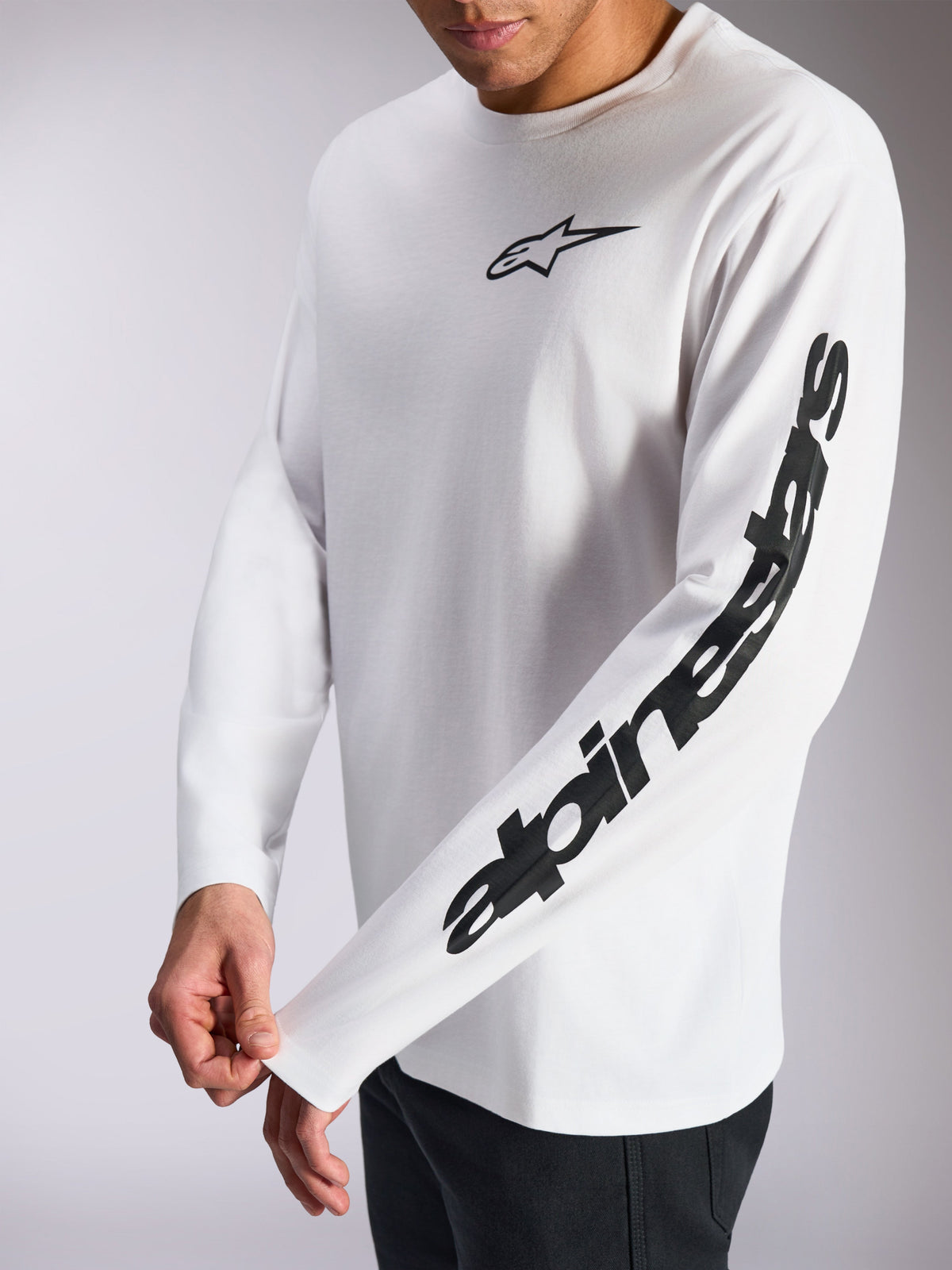 Alpinestars Trackside CSF Tee, Langarm-T-Shirt, Weiß und Schwarz, kleines schwarzes Stern-Logo auf der Brust und markanter Schriftzug auf dem Ärmel, lässige, vom Motorsport inspirierte Streetwear