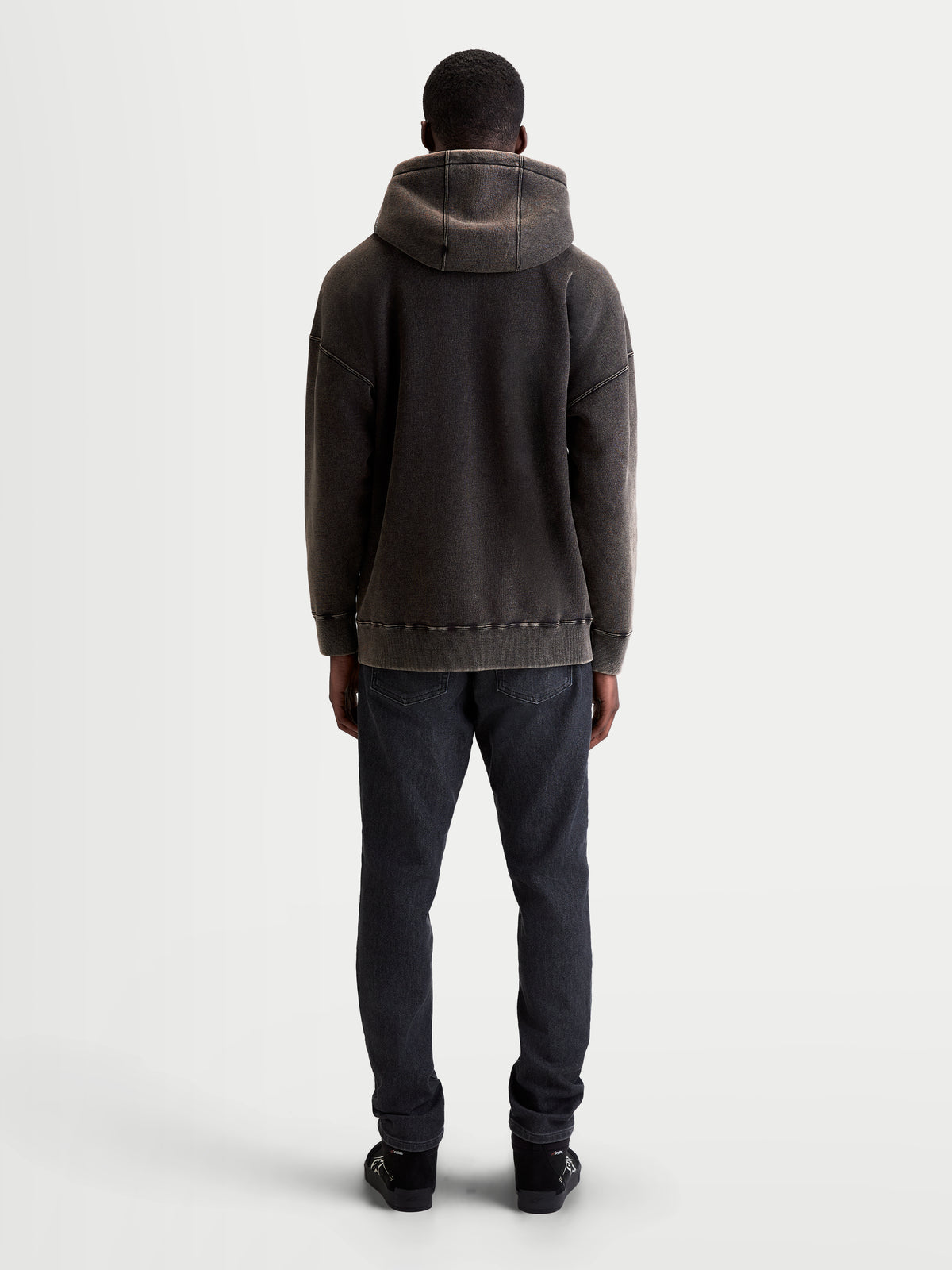 Alpinestars Infinite Washed Oversized Hoodie, lässiger Sportswear-Kapuzenpullover, Unisex, Schwarz, weiches Fleece mit Snow-Wash-Finish, Rückansicht mit lockerer Passform, Kapuzendetail und geripptem Saum.