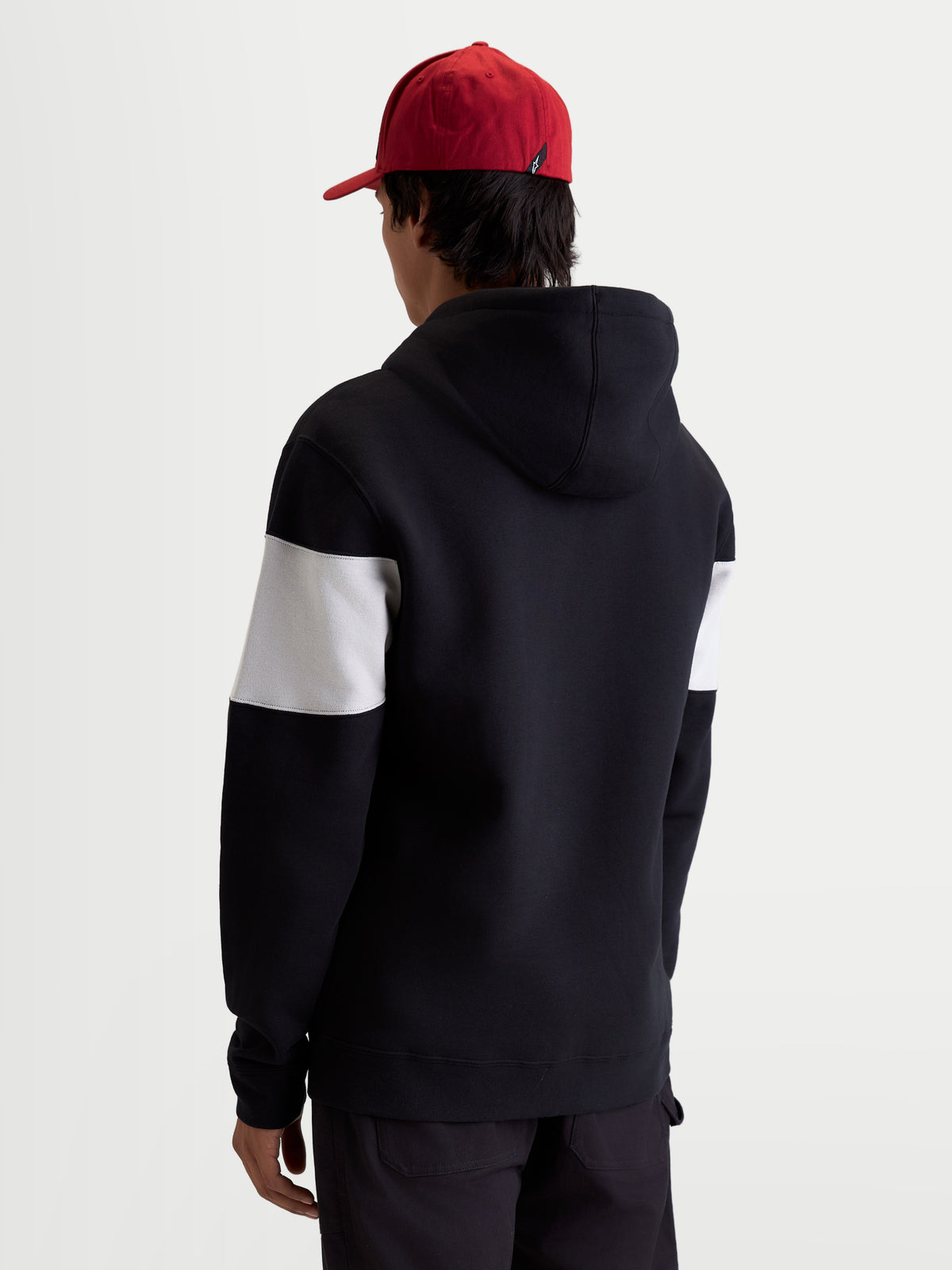 Alpinestars Cubic Hoodie, Sportswear Kapuzenpullover, Schwarz und Weiß, mit Color-Block-Design an den Ärmeln, Baumwoll- und Recycling-Polyester-Mischung, Rückansicht am Modell für einen lässigen Freizeit-Style.