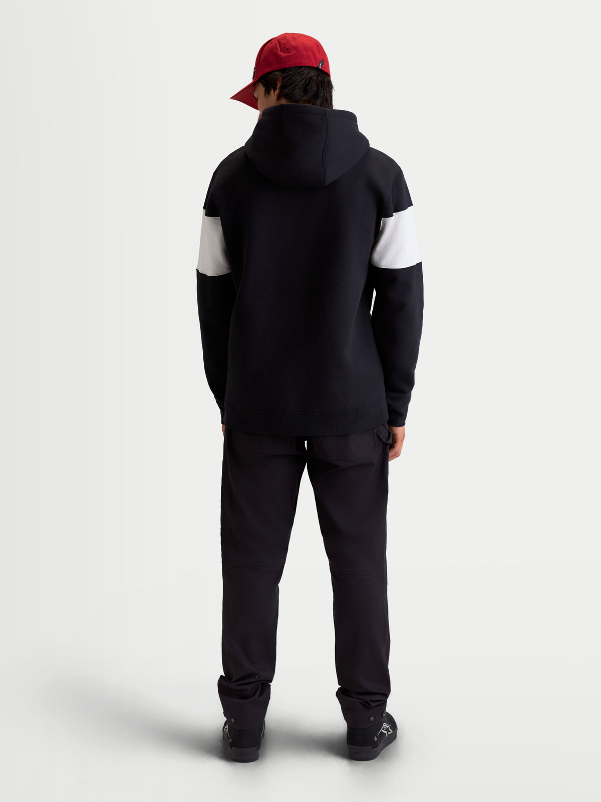 Alpinestars Cubic Hoodie, Unisex-Sportswear-Kapuzenpullover aus Fleece, Color-Block-Design mit Ärmeln in Schwarz und Weiß, Rückansicht am Model, hochwertige Baumwollmischung, lässige Off-Bike-Bekleidung.
