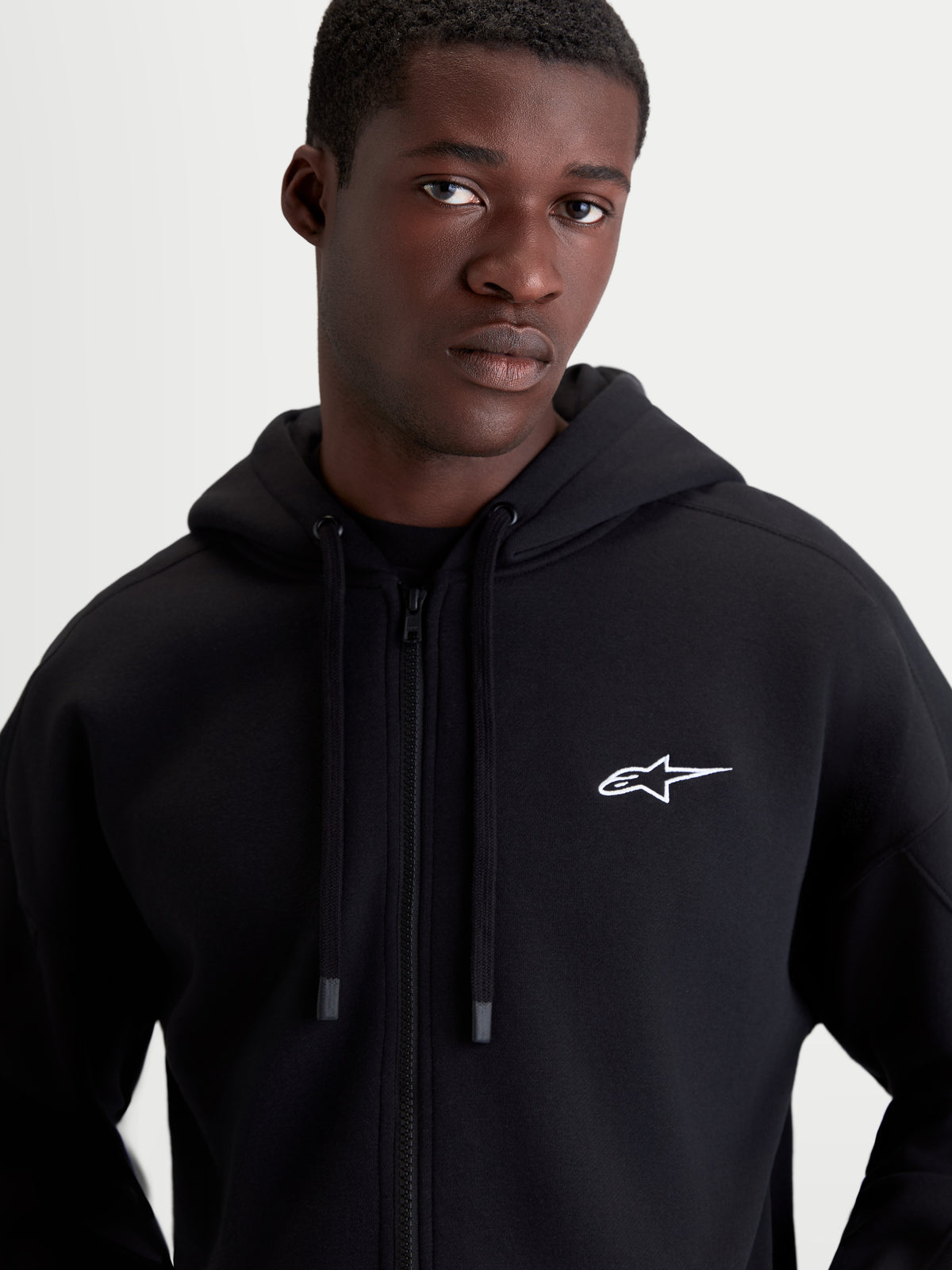Alpinestars Entity Oversized Hoodie, Herren-Sportswear-Fleecejacke mit Reißverschluss, Schwarz und Weiß, Motorsport-Lifestyle, entspannte Oversized-Passform, Vislon-Frontreißverschluss, selbstgefütterte Kapuze mit flachen Kordelzügen, gesticktes Astars-Logo auf der Brust.