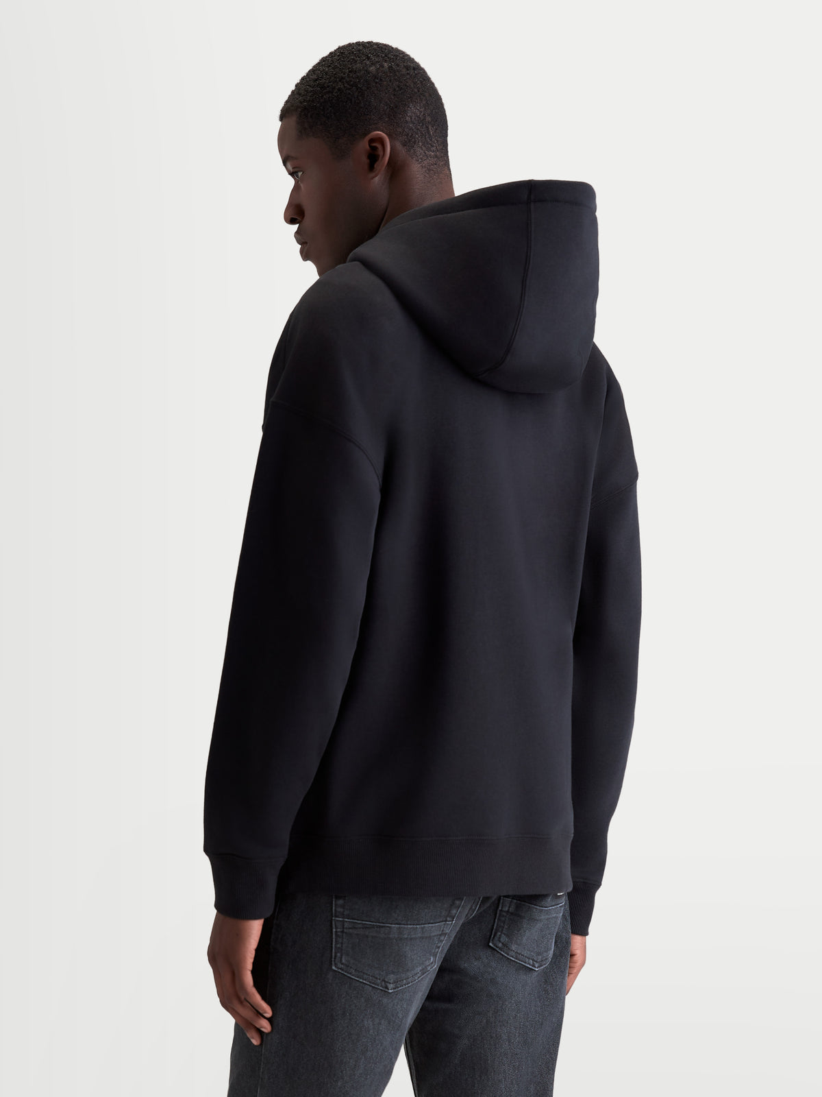 Alpinestars Entity Oversized Hoodie, Sportswear-Kapuzenjacke in Schwarz, Rückansicht am Model, Oversized-Passform, Premium-Baumwollmischung mit recyceltem Polyester, gerippte Abschlüsse und selbstgefütterte Kapuze.