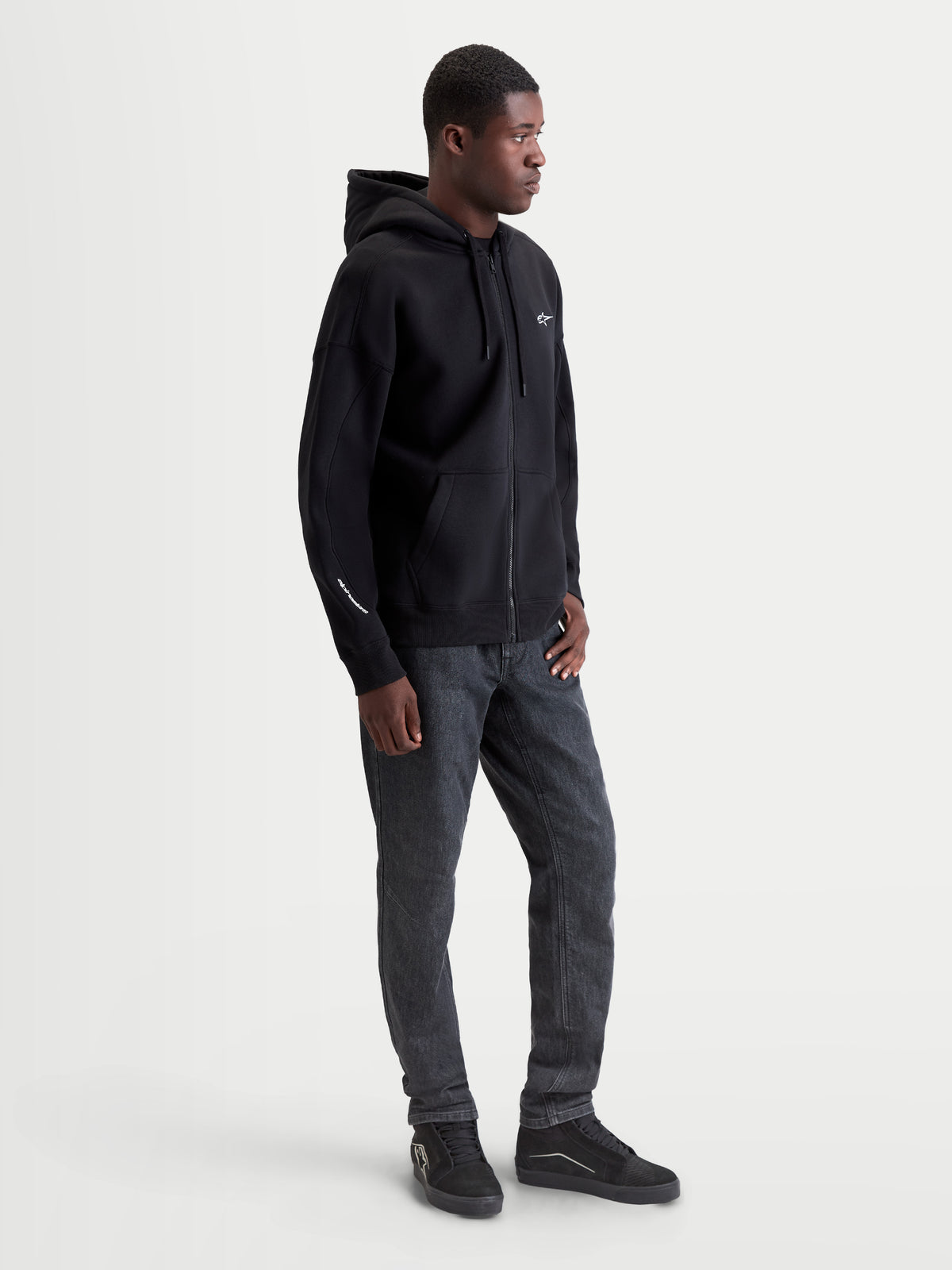 Alpinestars Entity Oversized Hoodie, Herren Sportswear Kapuzenjacke mit Reißverschluss, Schwarz, Oversized-Passform, Baumwolle und recyceltes Polyester, Vislon-Frontreißverschluss, Kängurutasche, weiße Logo-Stickerei auf Brust und Ärmel.