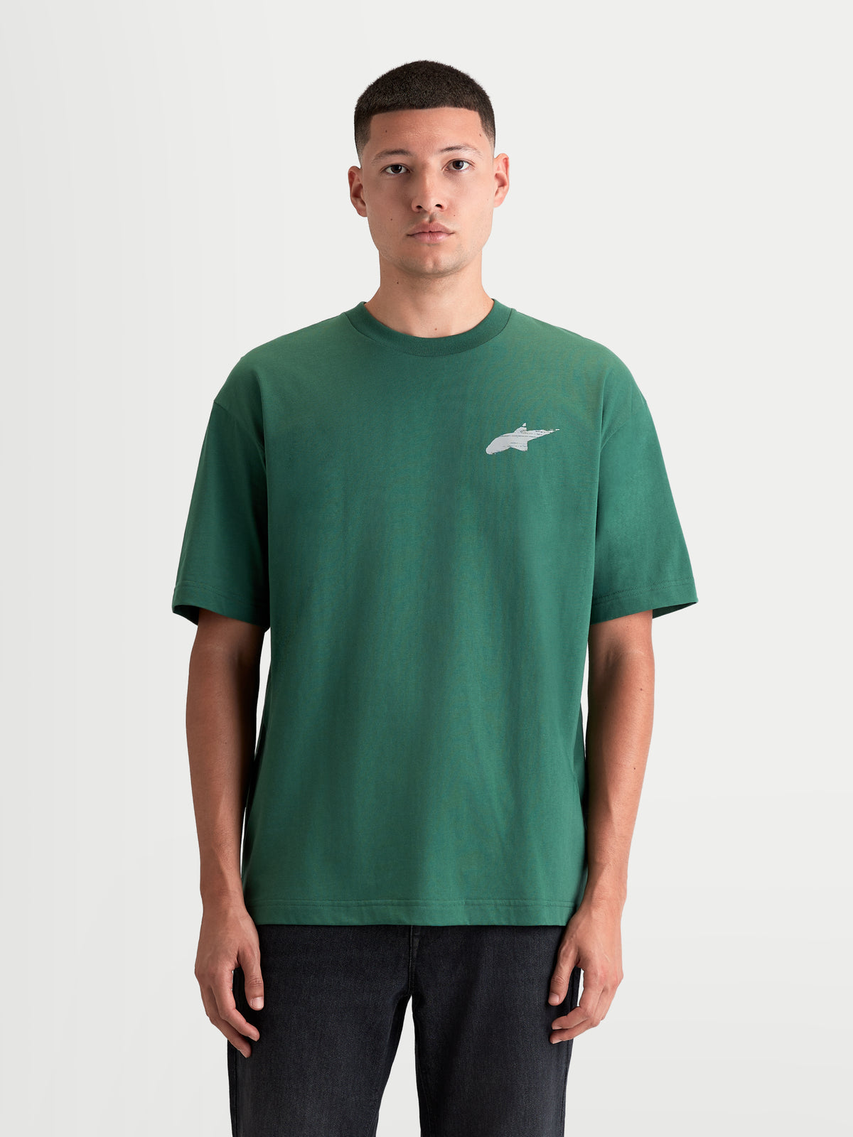 Alpinestars Checkback Oversized CSF T-Shirt, Herren-Sportswear Kurzarm-T-Shirt in Grün und Weiß, Vorderansicht am Modell mit lockerer Oversized-Passform und Astars-Logo auf der Brust, Motorsport-inspiriertes Oberteil aus Baumwoll-Polyester-Mischung.