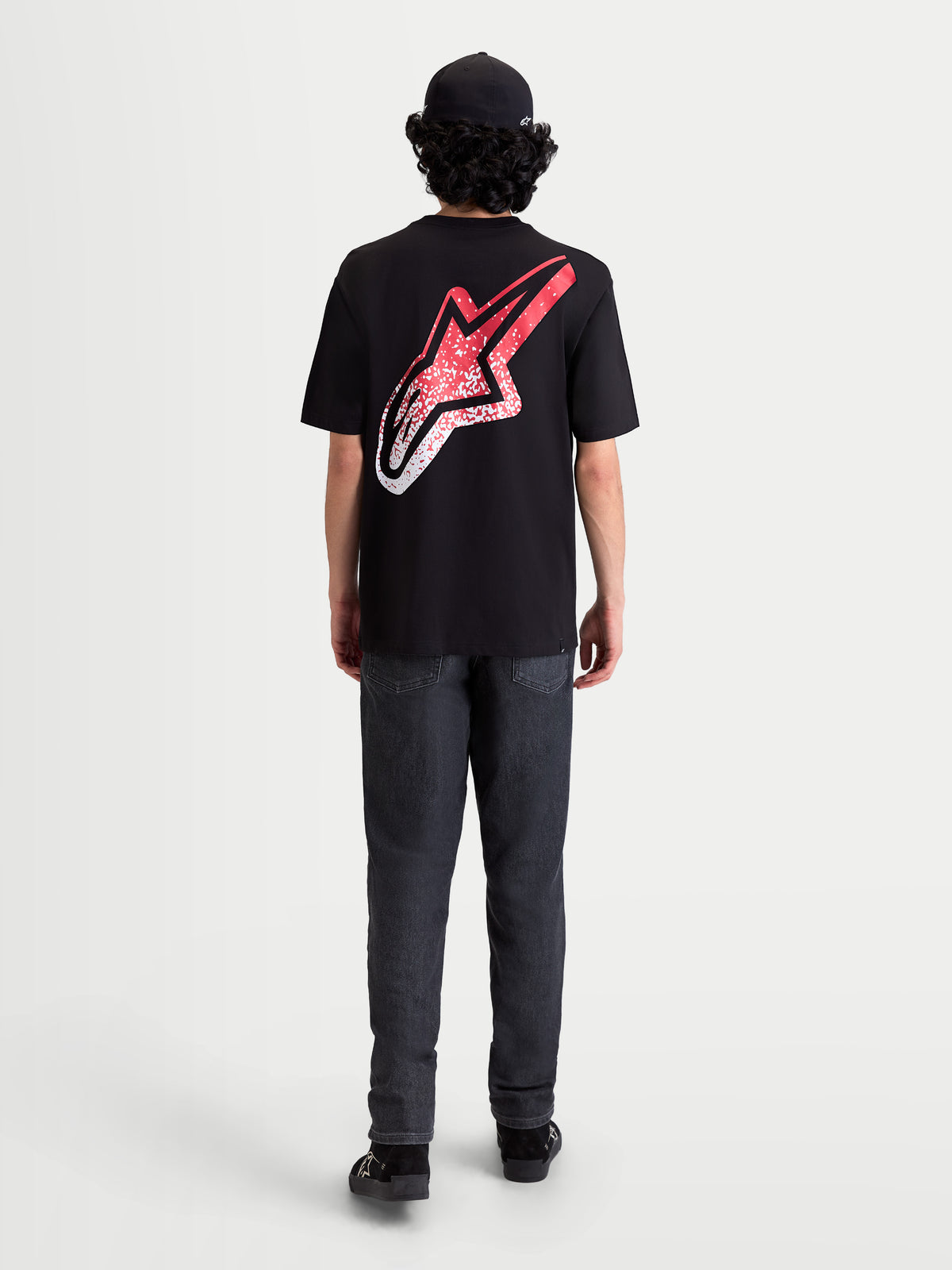 Alpinestars Meteor CSF T-Shirt, Kurzarm-Sportswear-T-Shirt, Schwarz, Rot und Weiß. Rückansicht am Modell mit großem Astars-Logo auf dem Rücken und MX-inspiriertem rot-weißem Farbverlauf.