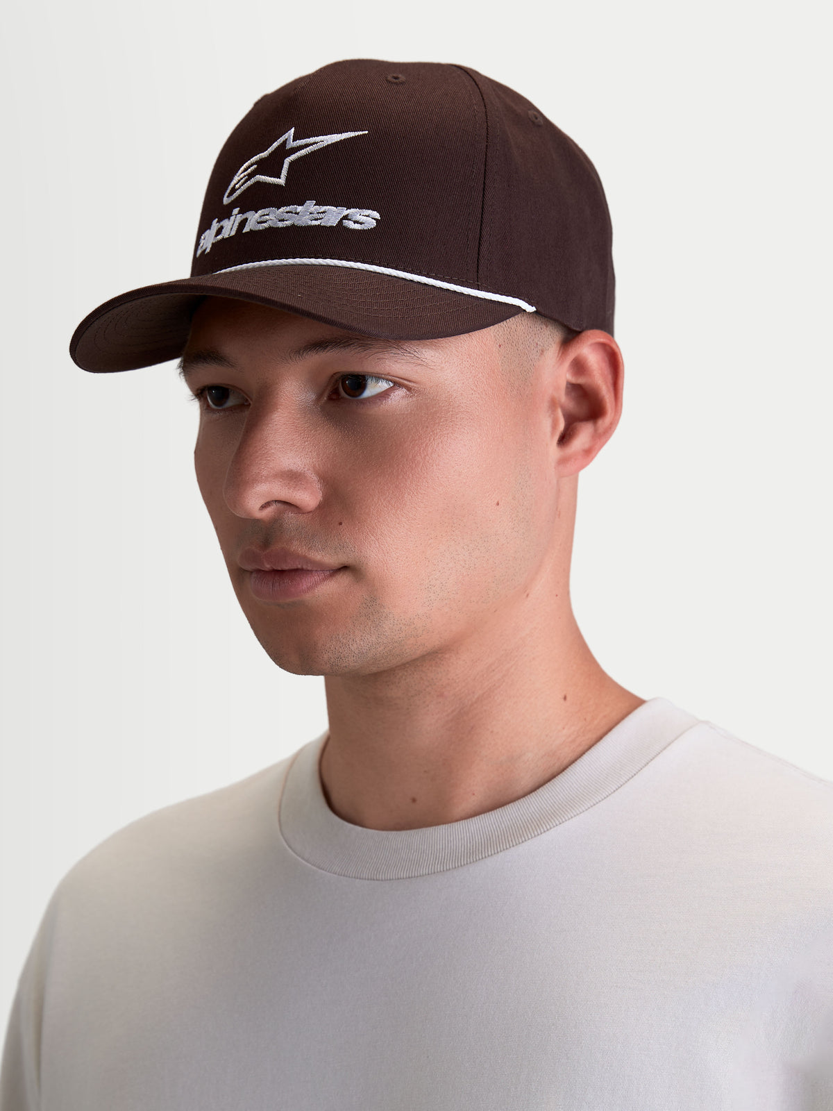 Alpinestars Combo Logo Snapback Kappe, braune Sportswear-Kappe, Lifestyle-Baseballcap mit weißer Logo-Stickerei und Kordel-Detail, strukturierte Krone und gebogener Schirm, Herren-Accessoire aus 100 % Baumwolltwill, Braun und Weiß.