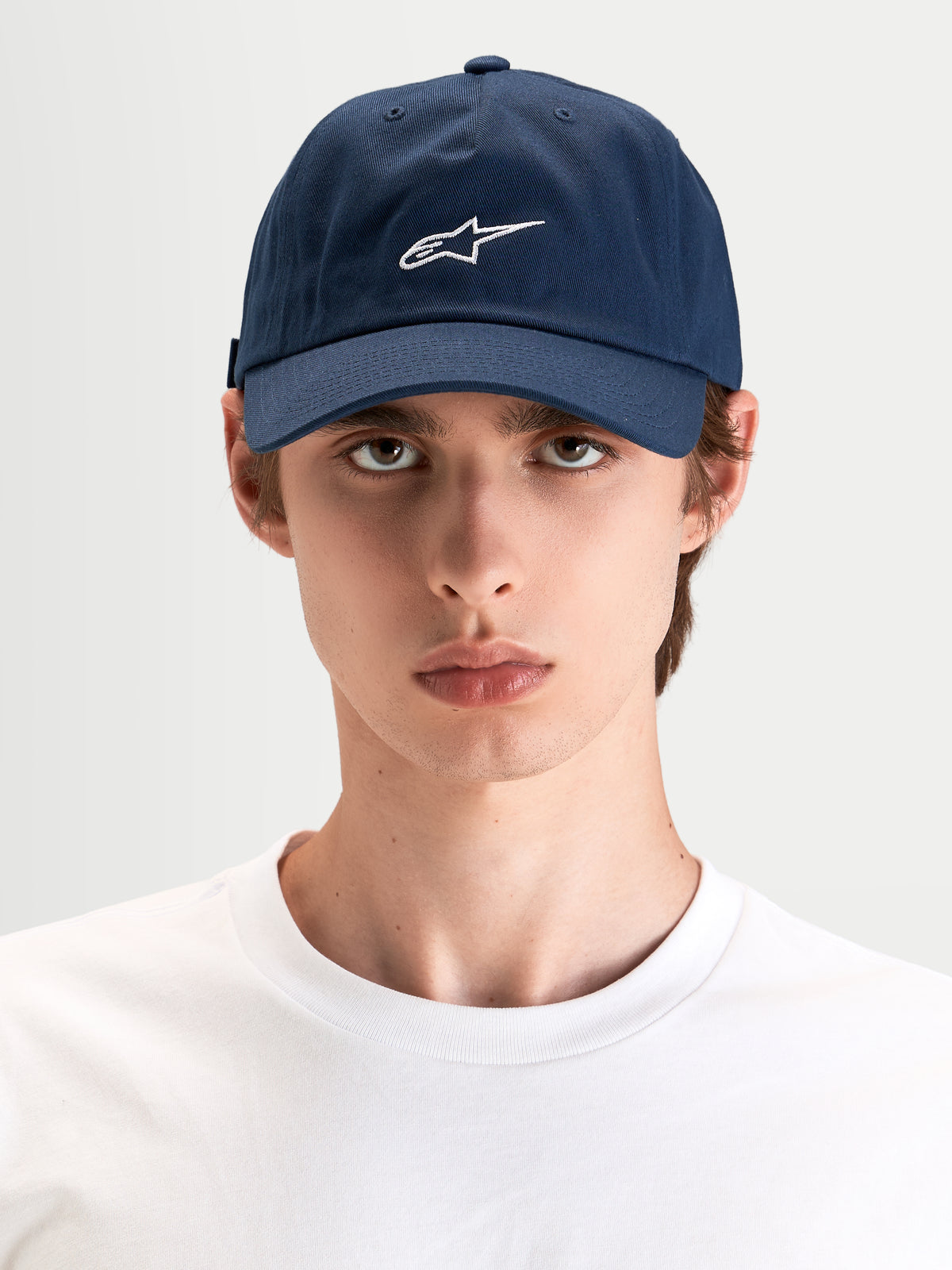 Alpinestars Dylan Dad-Kappe, marineblaue Sportswear-Kappe mit weißer Astars-Logo-Stickerei, gebogenem Schirm und unstrukturierter niedriger Krone, getragen von einem Model