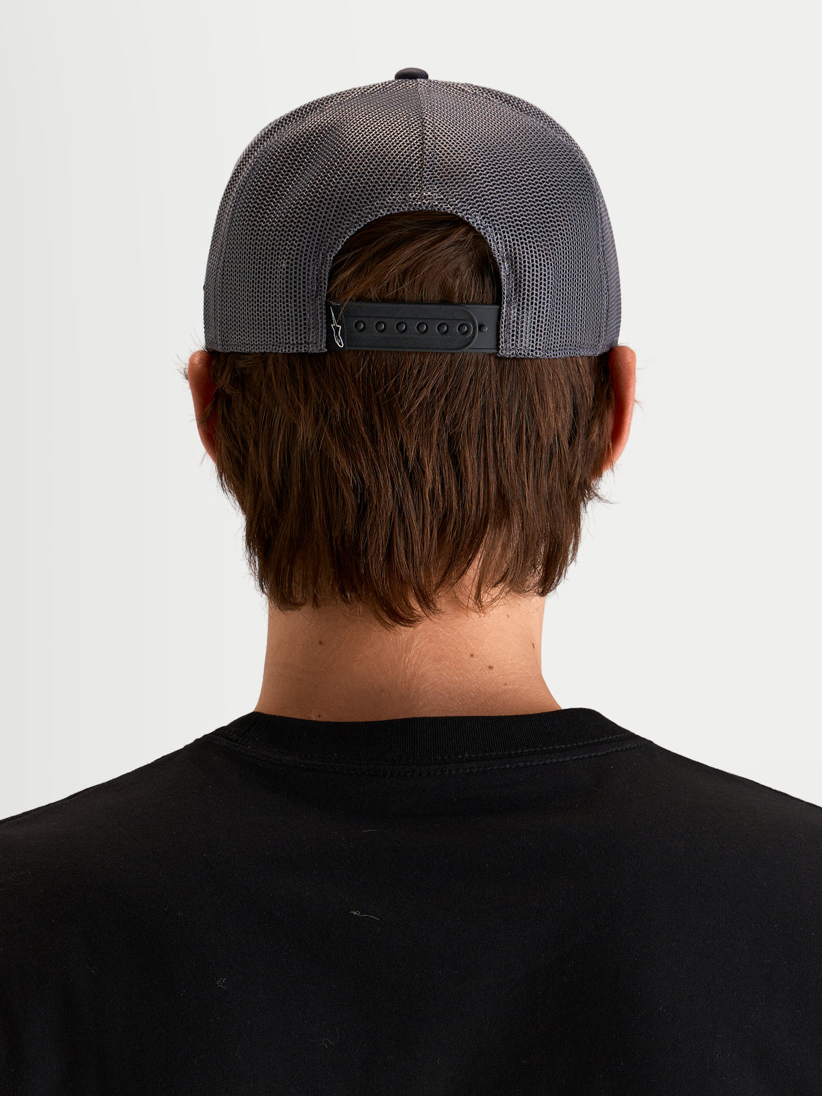 Alpinestars Ten Trucker-Kappe, dunkelgraue Trucker-Cap in Dunkelgrau, Rückansicht an Model mit verstellbarem Snapback-Verschluss und Mesh-Einsätzen am Hinterkopf