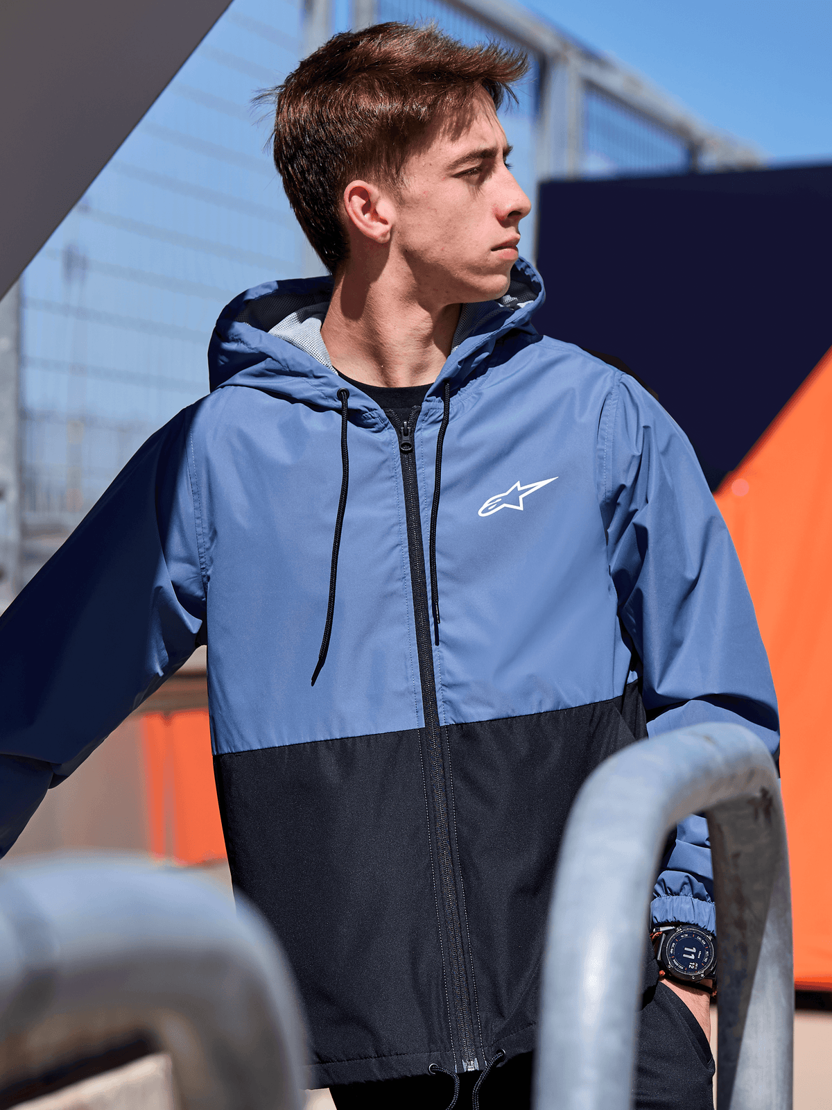 Alpinestars Speeder Windbreaker-Jacke, leichte Windbreaker-Jacke mit Kapuze, Colorblock-Design in Schieferblau und Schwarz, weißes Alpinestars-Logo auf der Brust, mit Mesh gefüttert, Kapuze mit Kordelzug, lässige, vom Motorsport inspirierte Streetwear