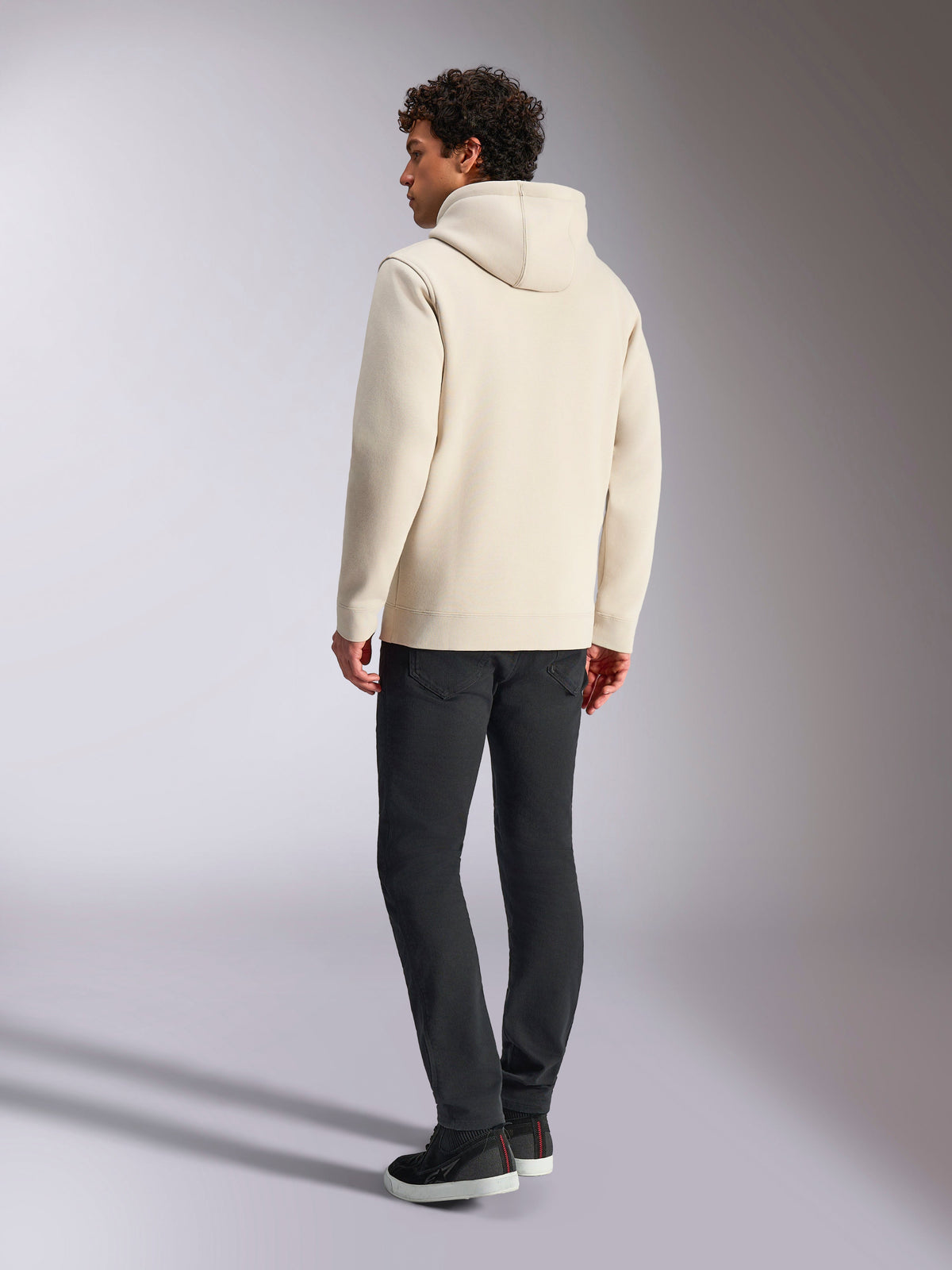 Alpinestars Always V3 Hoodie, Off-White, Rückansicht eines männlichen Models mit Hoodie und schwarzer Hose, lässige vom Motorsport inspirierte Streetwear, minimalistisches Design mit Kapuze und geripptem Saum