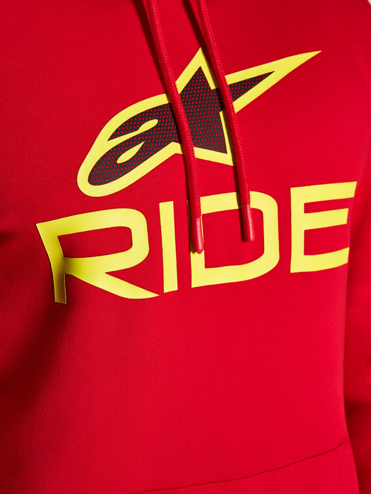 Alpinestars Ride V3 Hoodie, Nahaufnahme der Brustgrafik, Rot mit neongelbem RIDE-Schriftzug und schwarzem perforiertem Stern-Logo, rote Kordelzüge mit getauchten Enden, Premium-Fleece, lässige Streetwear