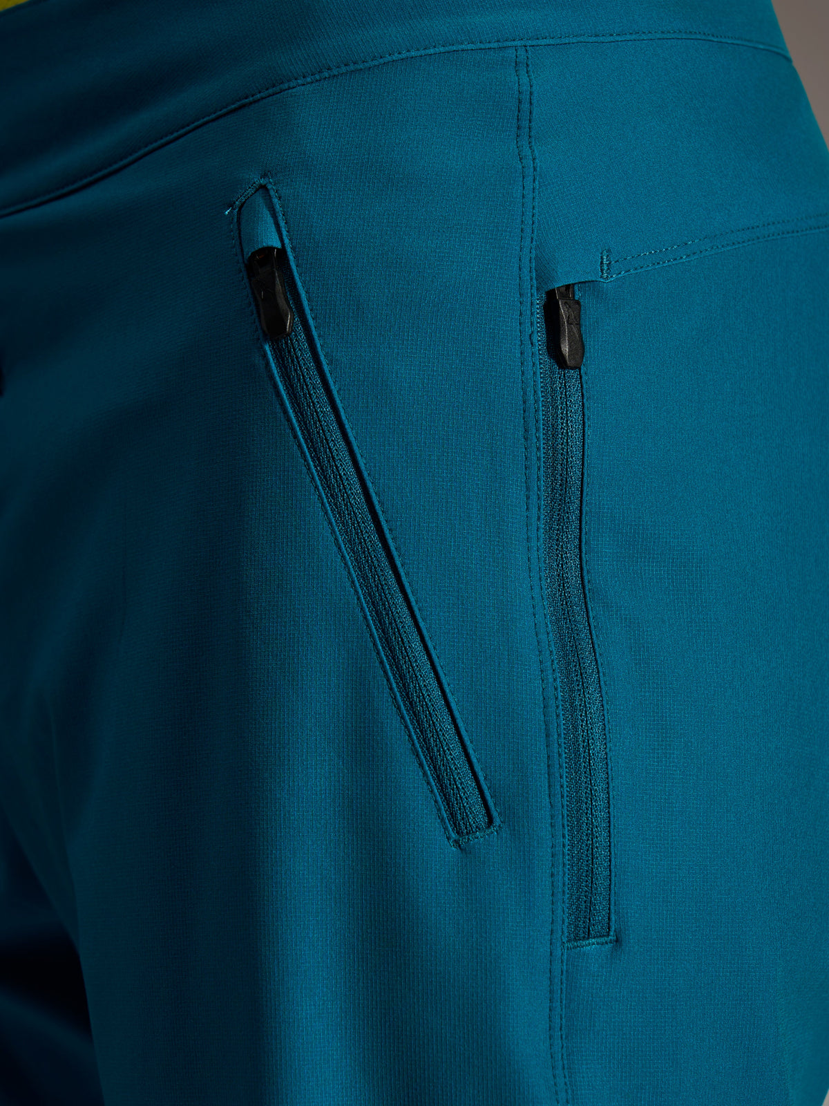 Seitliche Reißverschlusstaschen der blaugrünen Alpinestars A-Dura Ride Shorts aus robustem 4-Wege-Stretch-Gewebe.
