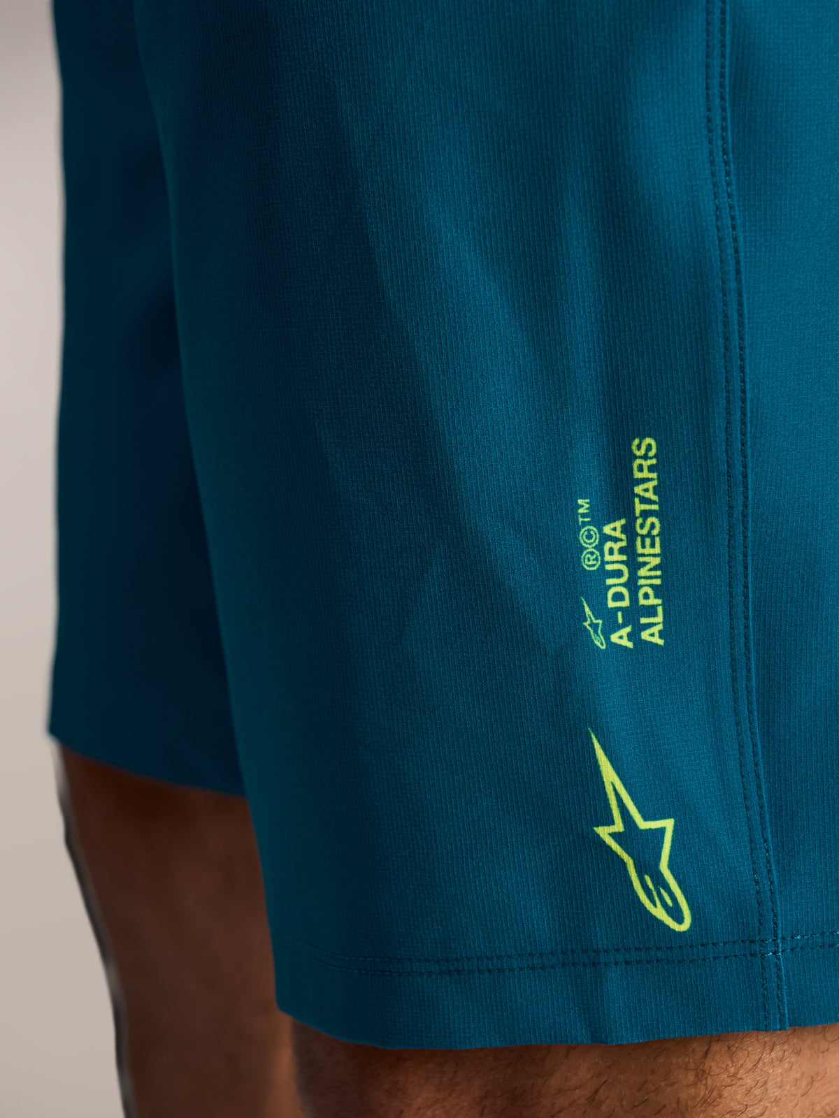 A-Dura Ride MTB Shorts in Blaugrün mit limettengrünem Alpinestars-Branding und Stern-Logo auf Stretch-Gewebe.