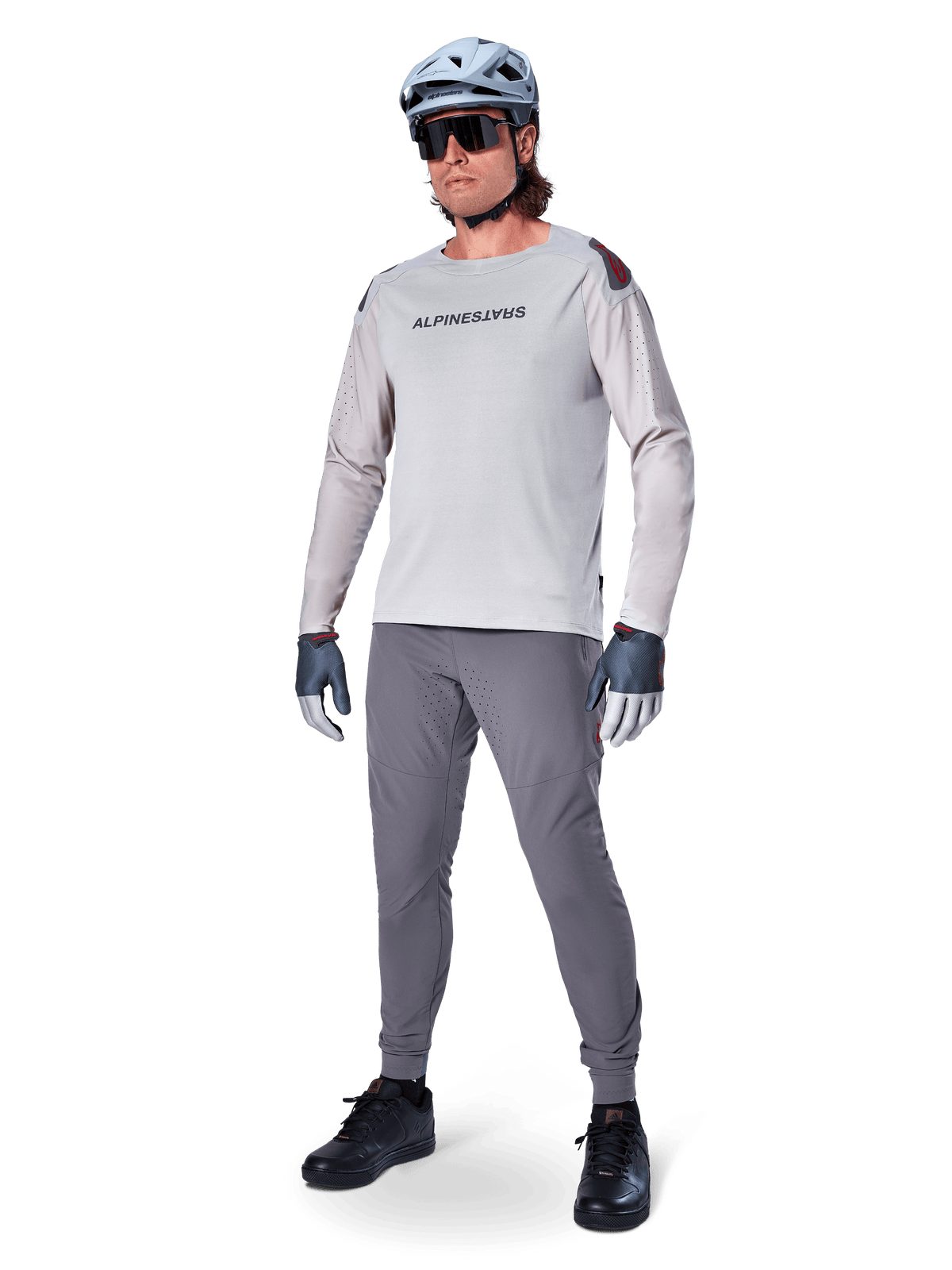 Alpinestars A-Aria Elite Hose, dunkelgraue MTB-Hose, getragen von einem Fahrer mit hellgrauem Langarmtrikot und grauem Helm, mit lasergeschnittener Belüftung an den Oberschenkeln und einer schmal zulaufenden Performance-Passform für das Mountainbiken.