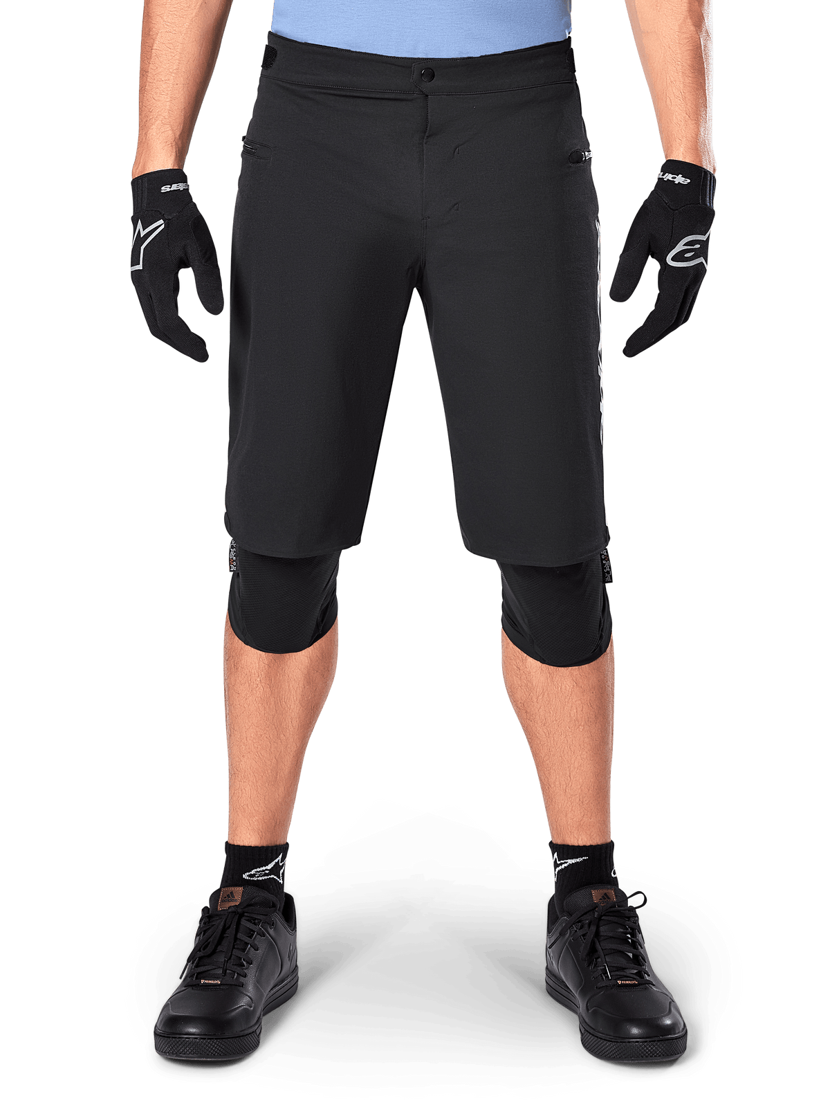 Alpinestars A-Dura Elite Shorts, Schwarze Mountainbike-Shorts, getragen von einem Fahrer mit schwarzen Handschuhen und Knieschonern, mit Druckknopfverschluss vorne und Reißverschlusstaschen, strapazierfähiges Cordura-Material für Offroad-Radsport