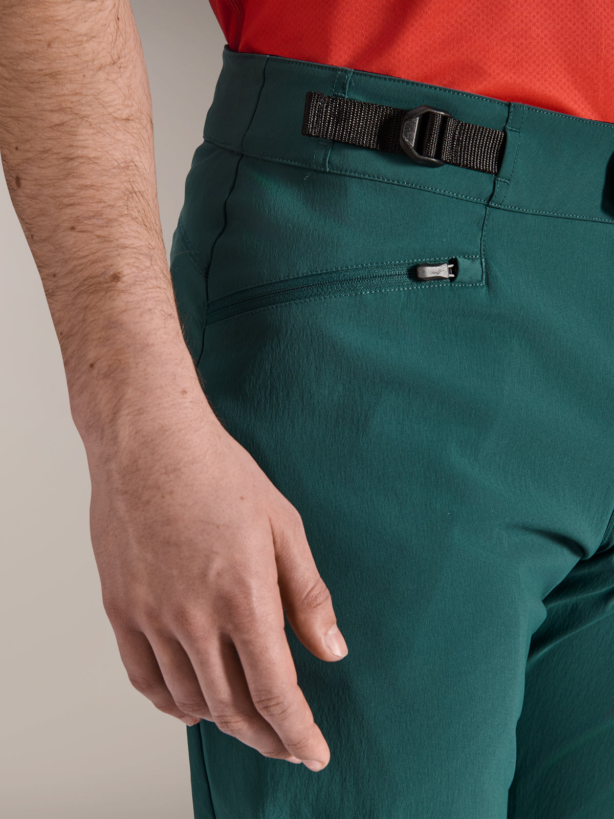Nahaufnahme der Alpinestars A-Dura Hose in Dark Pine Grün, mit verstellbarem seitlichem Zugverschluss und einer Reißverschlusstasche mit Mesh-Futter, strapazierfähige Mountainbike-Bekleidung für Offroad-Trail-Fahrten.