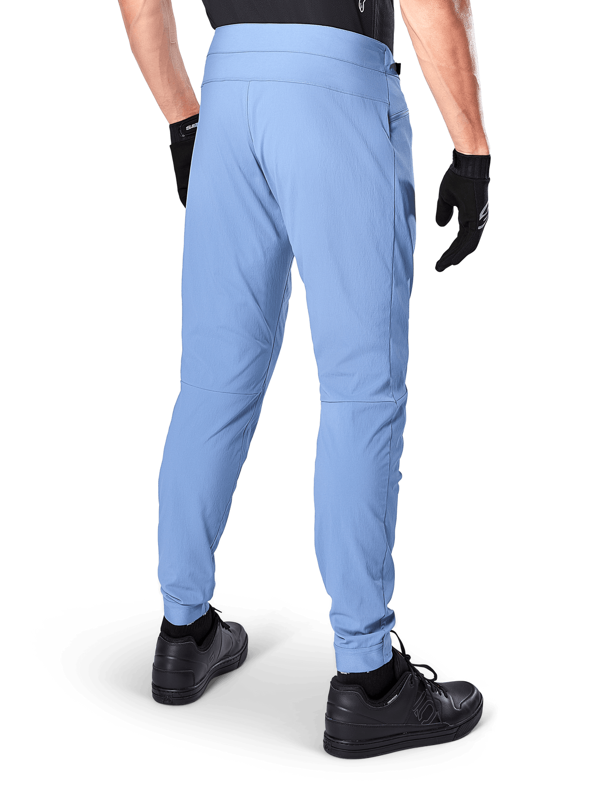 Alpinestars A-Dura Hose, Mountainbike-Hose, Infinity Blue, Rückansicht mit regulärer Passform und elastischen Bündchen, kombiniert mit schwarzen Handschuhen und schwarzem Schuhwerk, strapazierfähige 2-Wege-Stretch-Fahrradbekleidung.