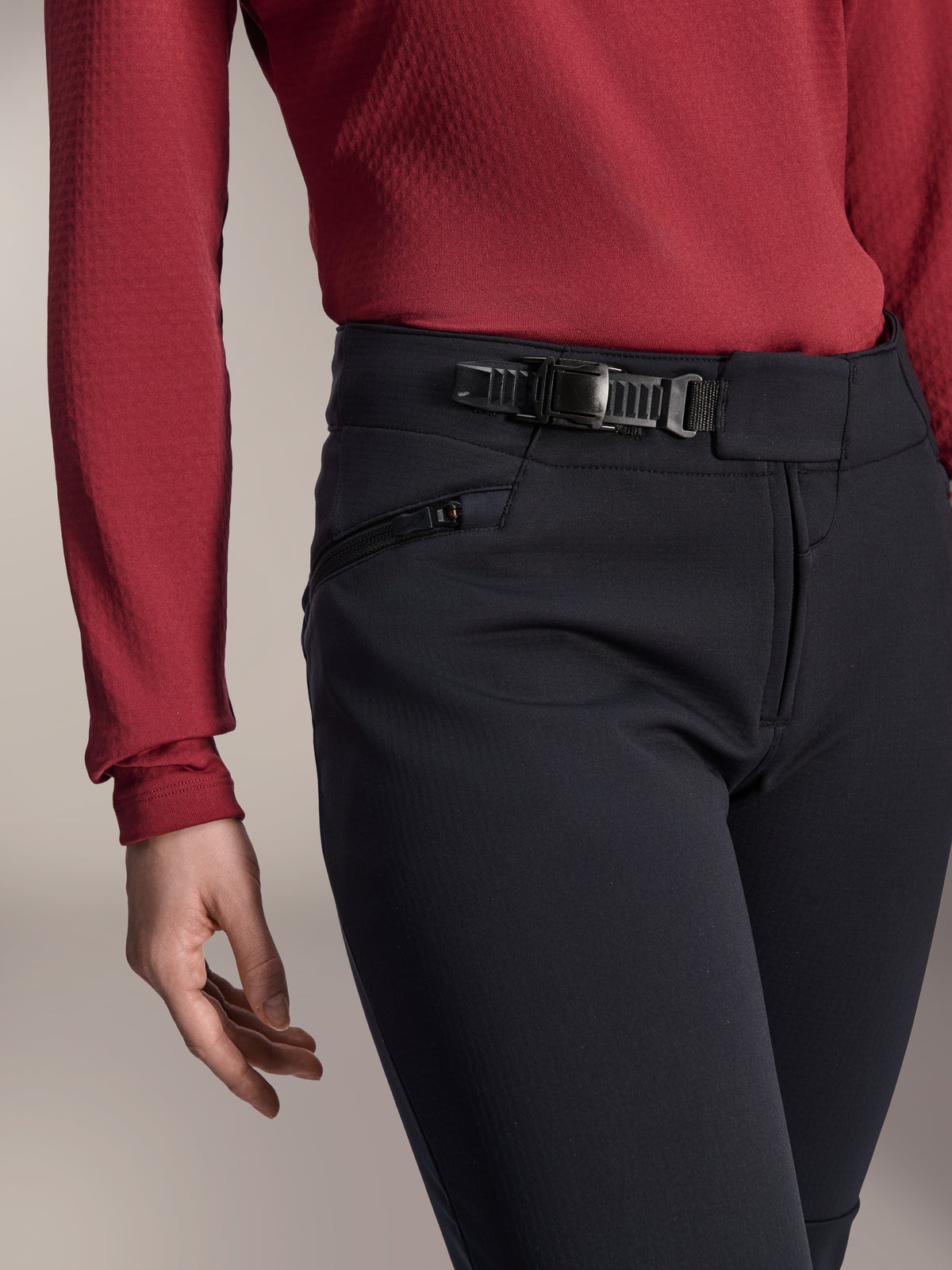 Alpinestars Stella A-Dura Thermal Hose, Damen-MTB-Hose, Schwarz, Nahaufnahme des Ratschenverschluss-Systems am Bund und der Seitentasche mit Reißverschluss, kombiniert mit einem dunkelroten Langarm-Oberteil, strapazierfähige Ausrüstung für Trailfahrten bei kaltem Wetter