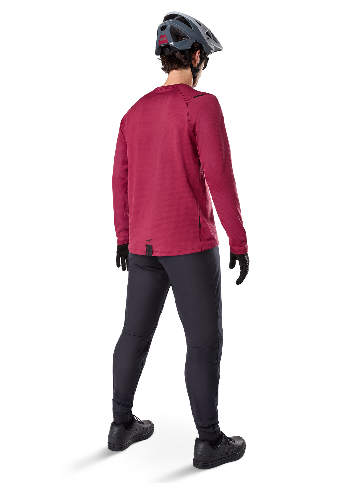 Alpinestars A-Dura Thermal Jersey, langärmeliges Radsport-Trikot in Burgunderrot, Rückansicht, getragen mit einer schwarzen Mountainbike-Hose und einem grauen Helm, mit verlängertem Rückenteil für zusätzlichen Schutz, Mountainbike-Ausrüstung für kaltes Wetter