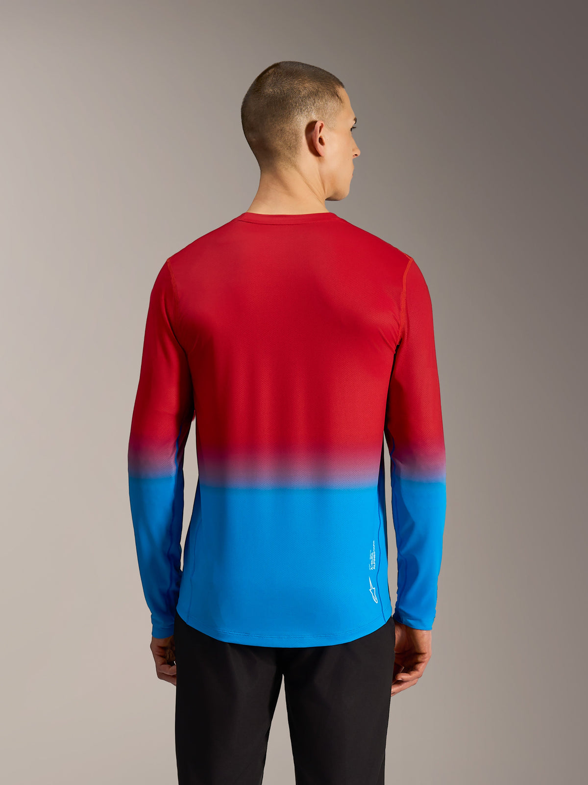 Rückansicht des Alpinestars A-Dura ASTARS 2.0 Langarm-MTB-Trikots mit Bright Red Blue Farbverlauf und verlängertem Rücken.