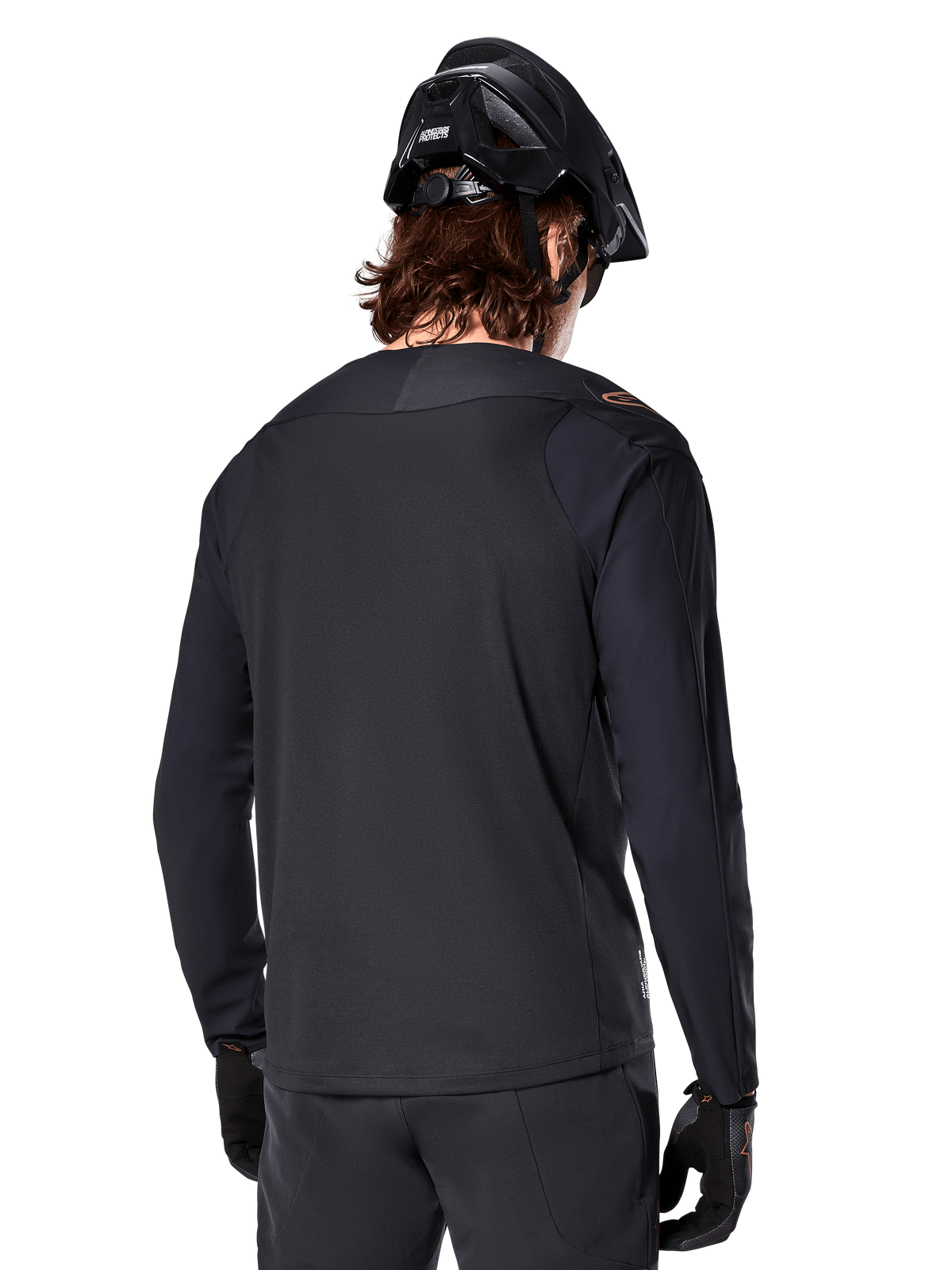 Alpinestars A-Aria Polartec Switch Langarmtrikot, Schwarz, Rückansicht, getragen mit schwarzem MTB-Helm und Handschuhen, mit verlängertem Saum für Offroad-Performance