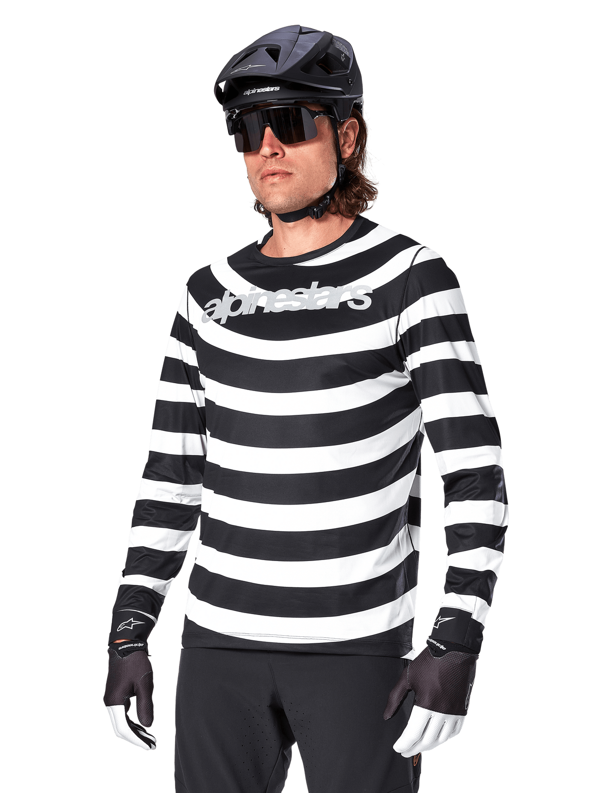 Alpinestars A-Aria Oscar Langarm-Trikot, MTB-Trikot, schwarz-weiß horizontal gestreift, getragen mit schwarzem Helm und Sonnenbrille, Alpinestars-Branding auf der Brust, Performance-Mountainbike-Bekleidung