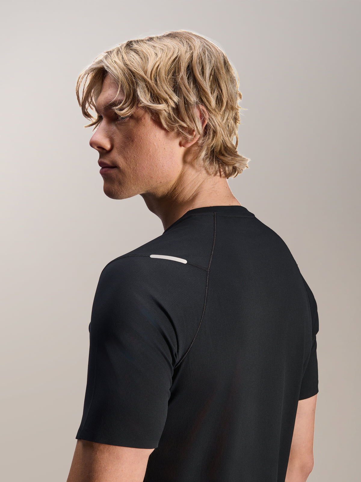 Mann im Alpinestars A-Aria Switch Kurzarmtrikot, Schwarz, Seiten- und Rückansicht zeigt die Performance-Passform und das Schulterdetail, leichte, atmungsaktive MTB-Radbekleidung