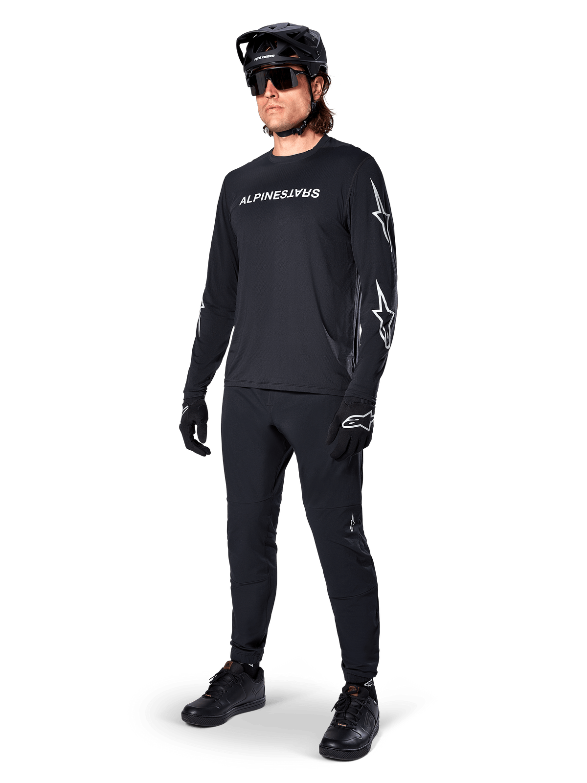Alpinestars A-Dura Switch Long Sleeve Jersey, Black, mountain bike jersey worn with black pants, helmet, and gloves, featuring white wordmark logo on chest and star logos on sleeves, coordinated MTB gear for off-road riding