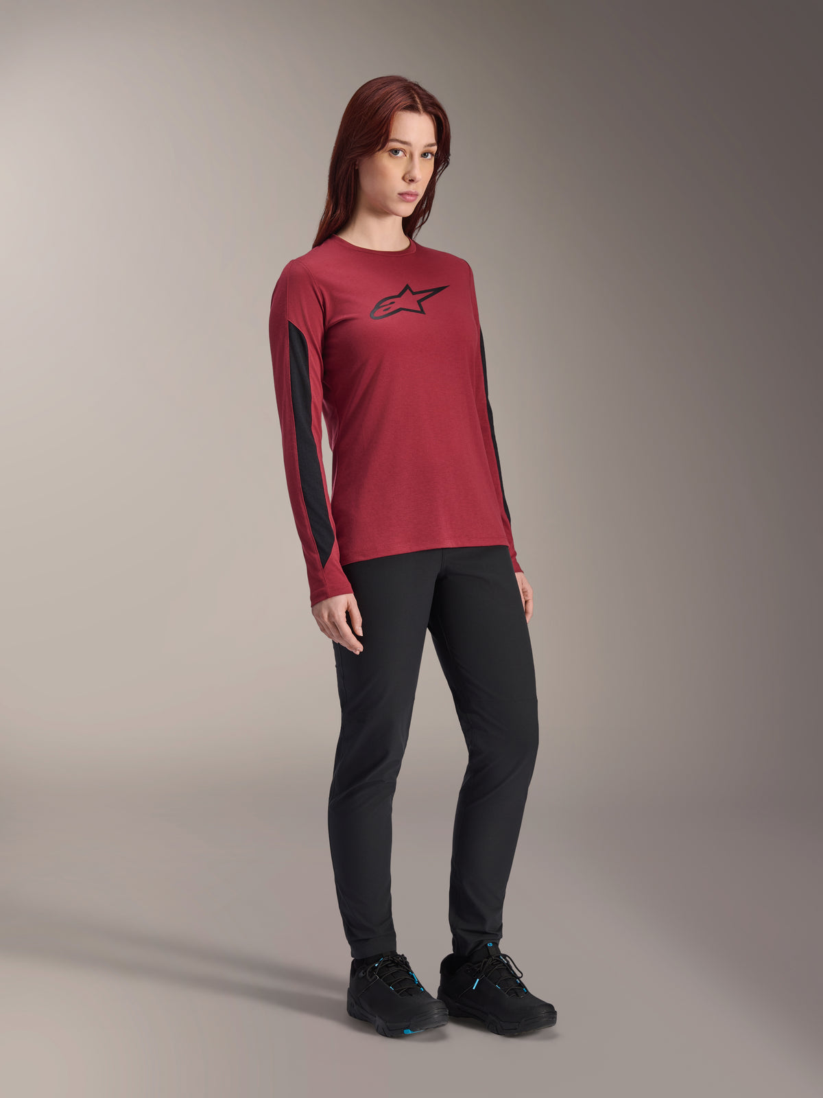 Alpinestars Women Stella A-Dura Dri Astar Long Sleeve Jersey, Burgundy red with black chest logo and black mesh panels on the sleeves, worn with black technical pants and black riding shoes, high-performance mountain bike apparel for women