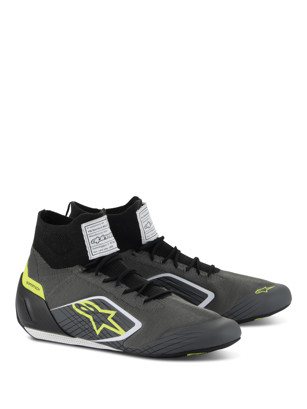 Alpinestars Supertech Shoes, Auto Racing Footwear, Cool Gray and Black with Fluo Yellow accents, featuring a knitted aramidic upper, carbon fiber heel cup, and white FIA certification labels on the tongue, professional motorsport design