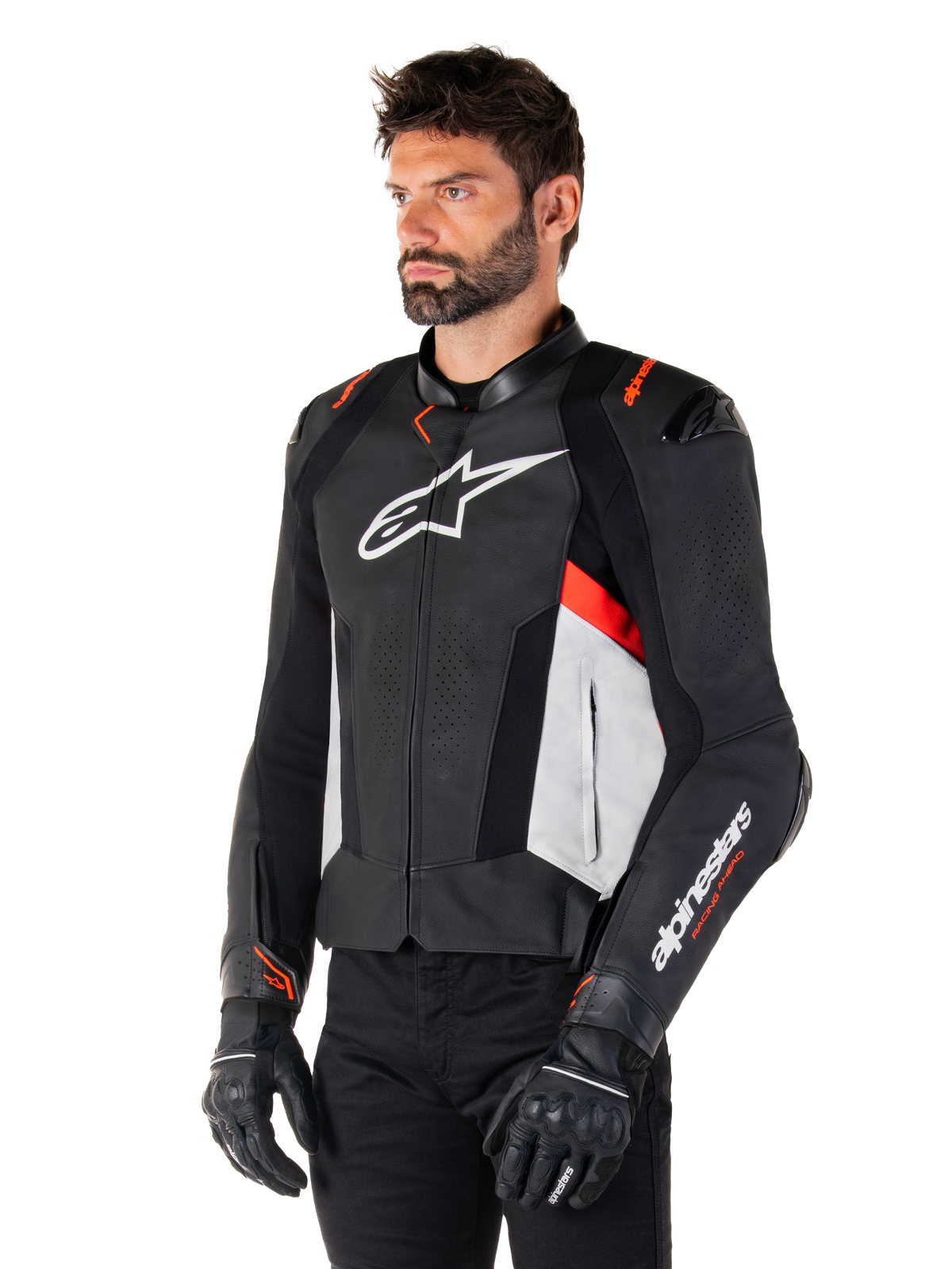Alpinestars Missile V3 Lederjacke, Schwarz Weiß und Rot Fluo, Rennsport-Motorradjacke getragen von einem Modell mit schwarzen Handschuhen und Hose, mit perforierten Lederbahnen und markantem Alpinestars-Branding
