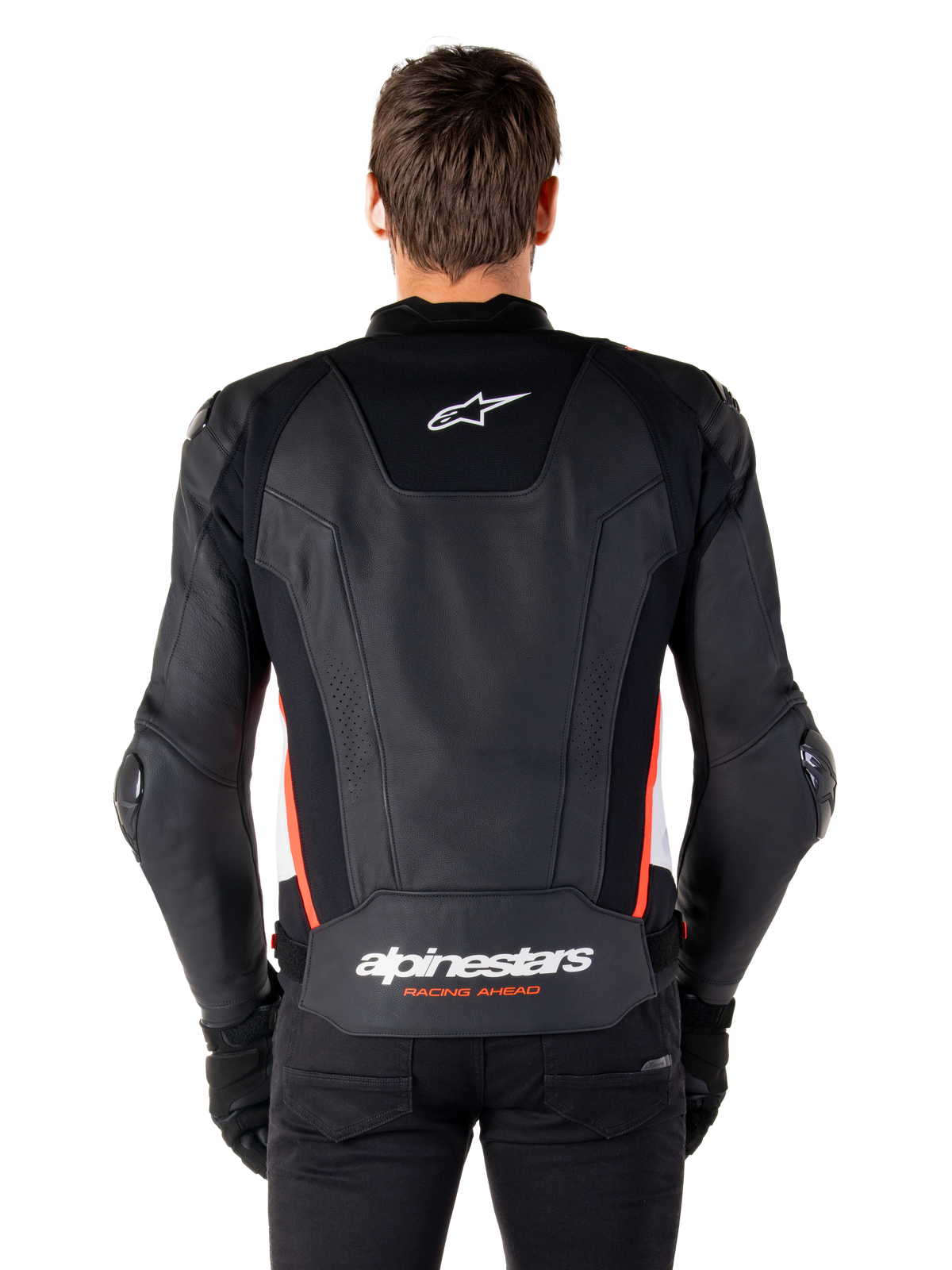 Alpinestars Missile V3 Lederjacke, Rückansicht, hochwertiges schwarzes Leder mit neongroten und weißen Akzenten, mit einem weißen Stern-Logo auf dem oberen Rücken und Alpinestars-Branding auf dem unteren Rücken, getragen mit schwarzer Hose und Handschuhen.